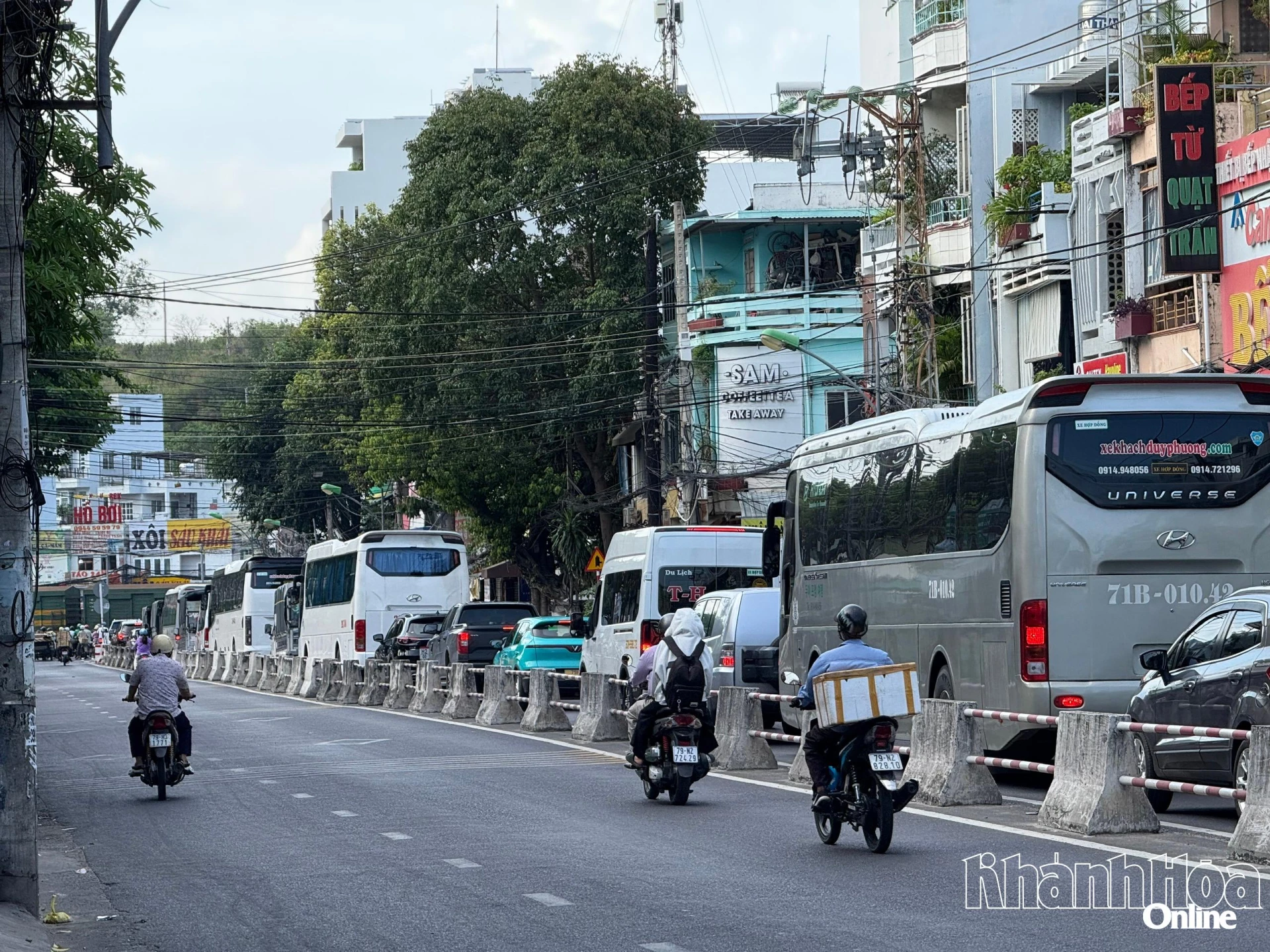 Nhiều  xe máy đi vào  làn ngược chiều trên đường Lê  Hồng Phong khi tàu hỏa chạy qua 