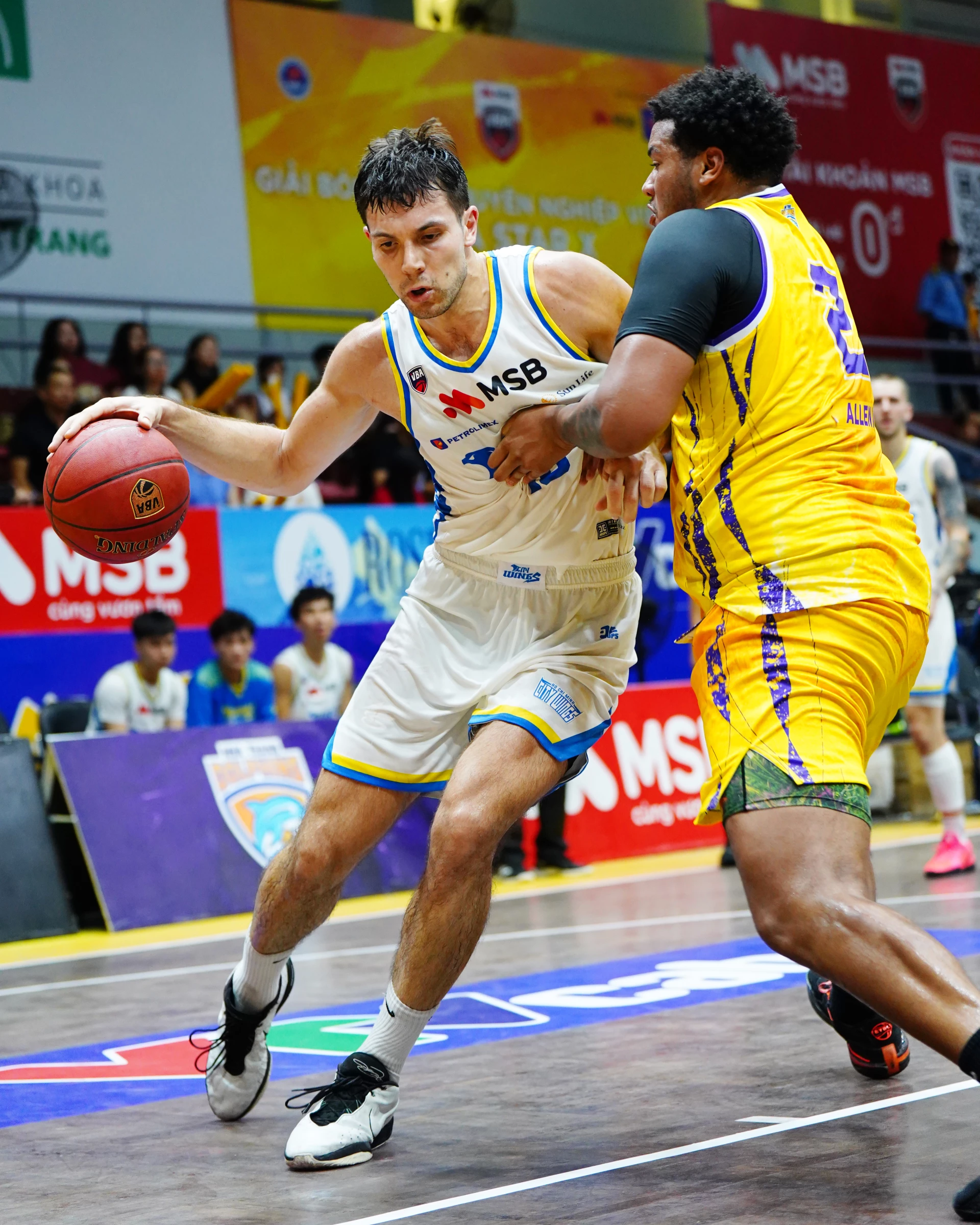 Ngôi sao gốc Việt Max Allen (bên phải) của đội Nha Trang Dolphins trong một pha ngăn chặn đối phương tấn công cận rổ.
