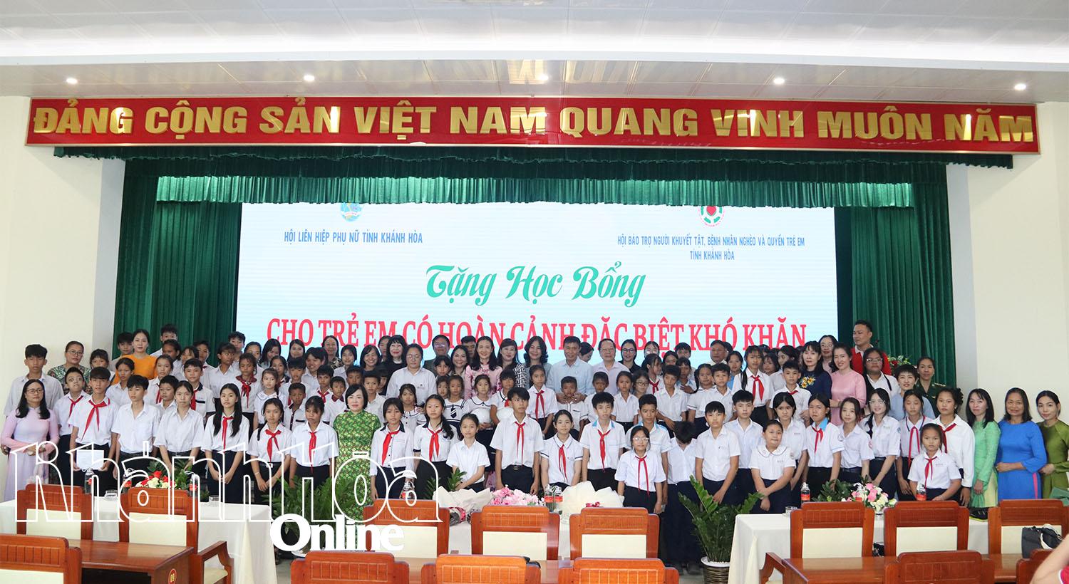 Các đại biểu, mẹ đỡ đầu chụp hình lưu niệm cùng các em nhận học bổng tại chương trình.