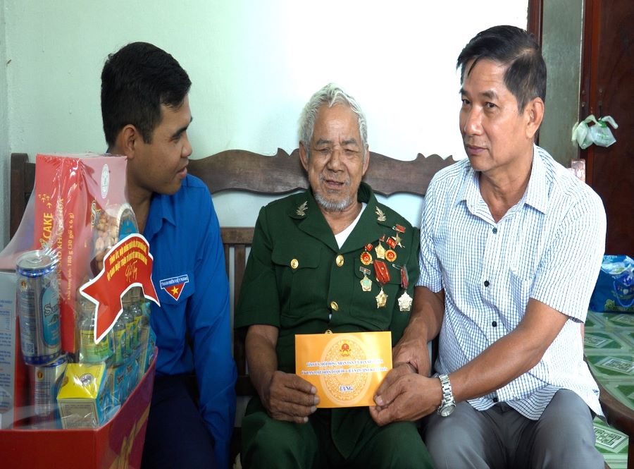 Bí thư Đảng ủy xã Đông Khánh Sơn trao quà cho ông Bo Bo Tới, Anh hùng Lực lượng vũ trang nhân dân.