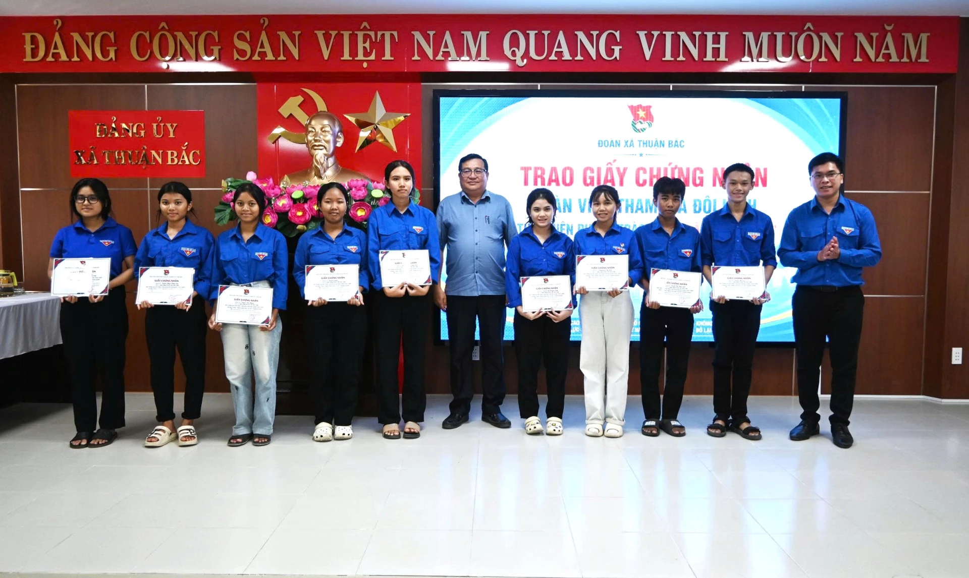 Ông Lữ Phụng Trường, Phó bí thư Đảng uỷ xã và lãnh đạo Đoàn xã  trao Giấy chứng nhận cho 10 đồng chí đã tham gia đội hình tình nguyện ra quân thực hiện phong trào “ Bình dân học vụ số’’ tháng 6/2026.