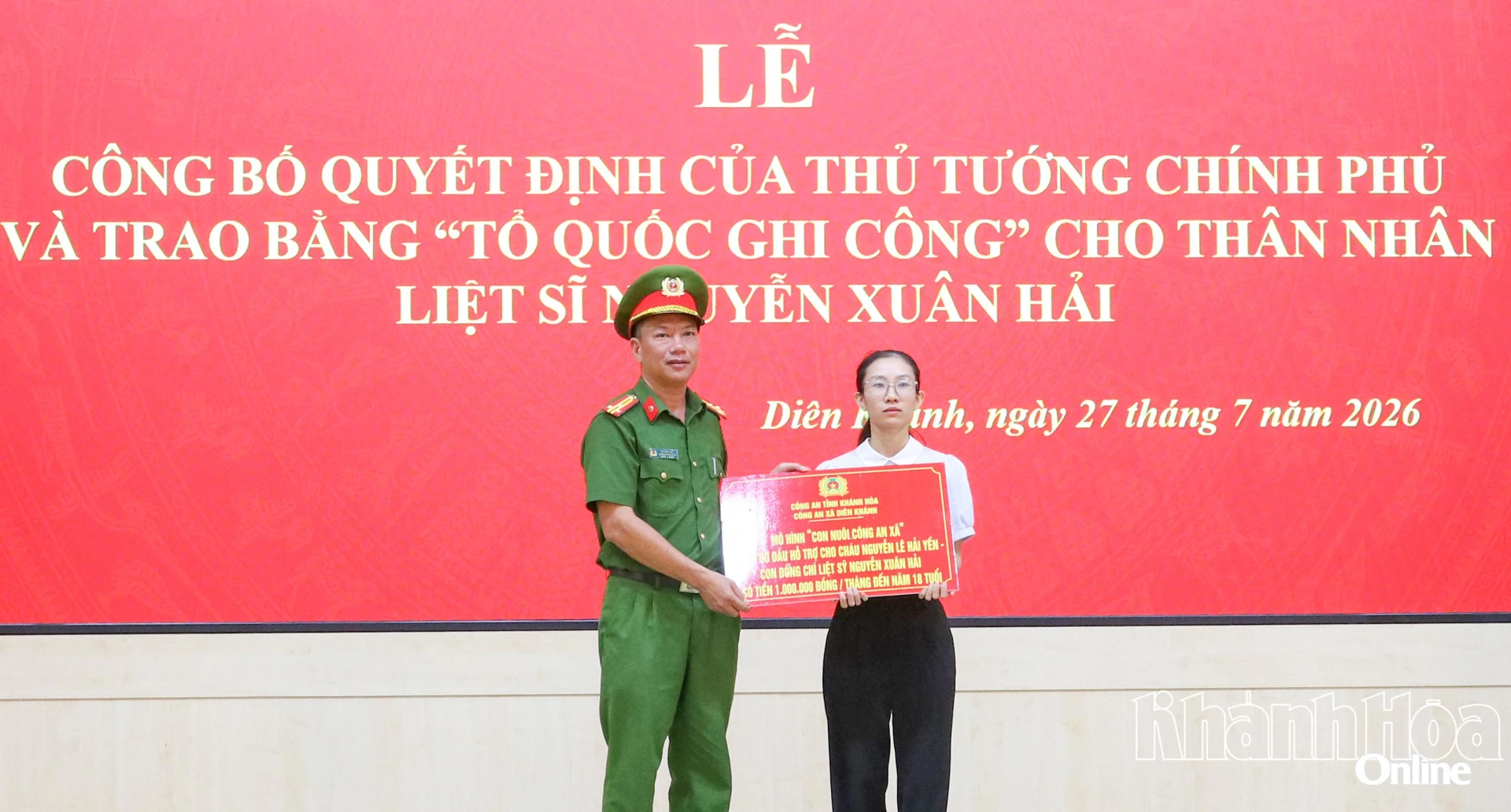 Công an xã Diên Khánh trao bảng tượng trưng mô hình “Con nuôi công an xã” cho thân nhân liệt sĩ Nguyễn Xuân Hải. 
