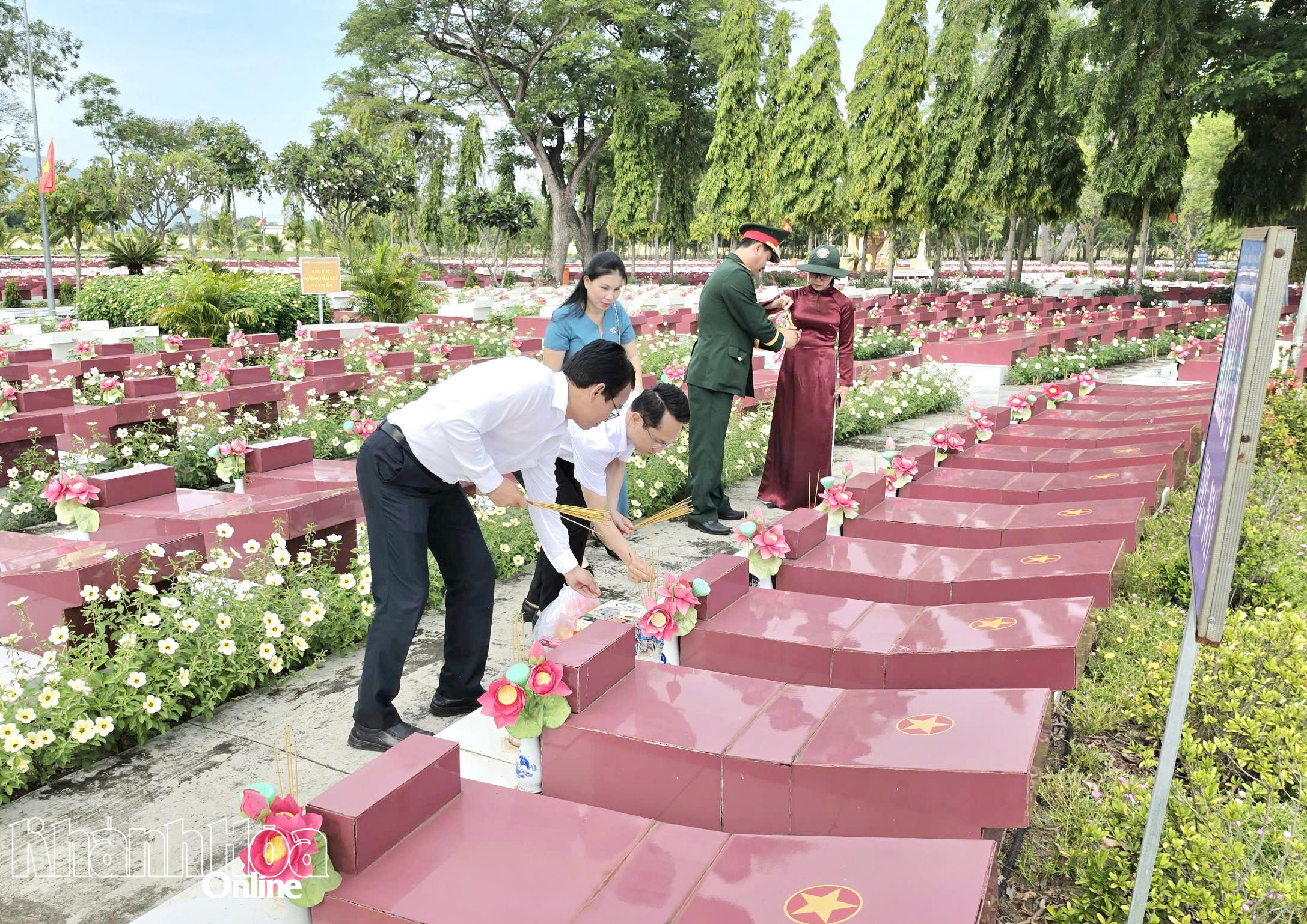 Thành viên đoàn các xã đến từng phần mộ để thắp những nén hương thơm.