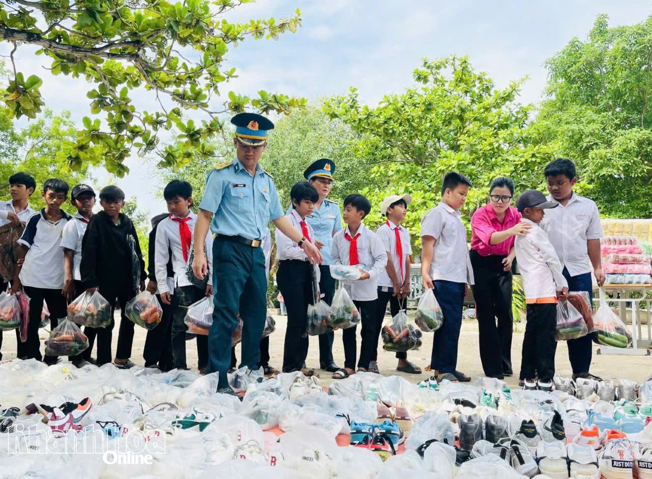 Ban tổ chức trao giày cho học sinh.