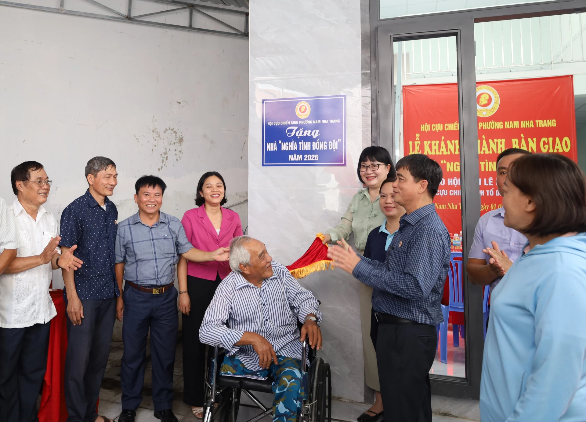 Các đại biểu thực hiện nghi thức kéo băng khánh thành nhà.