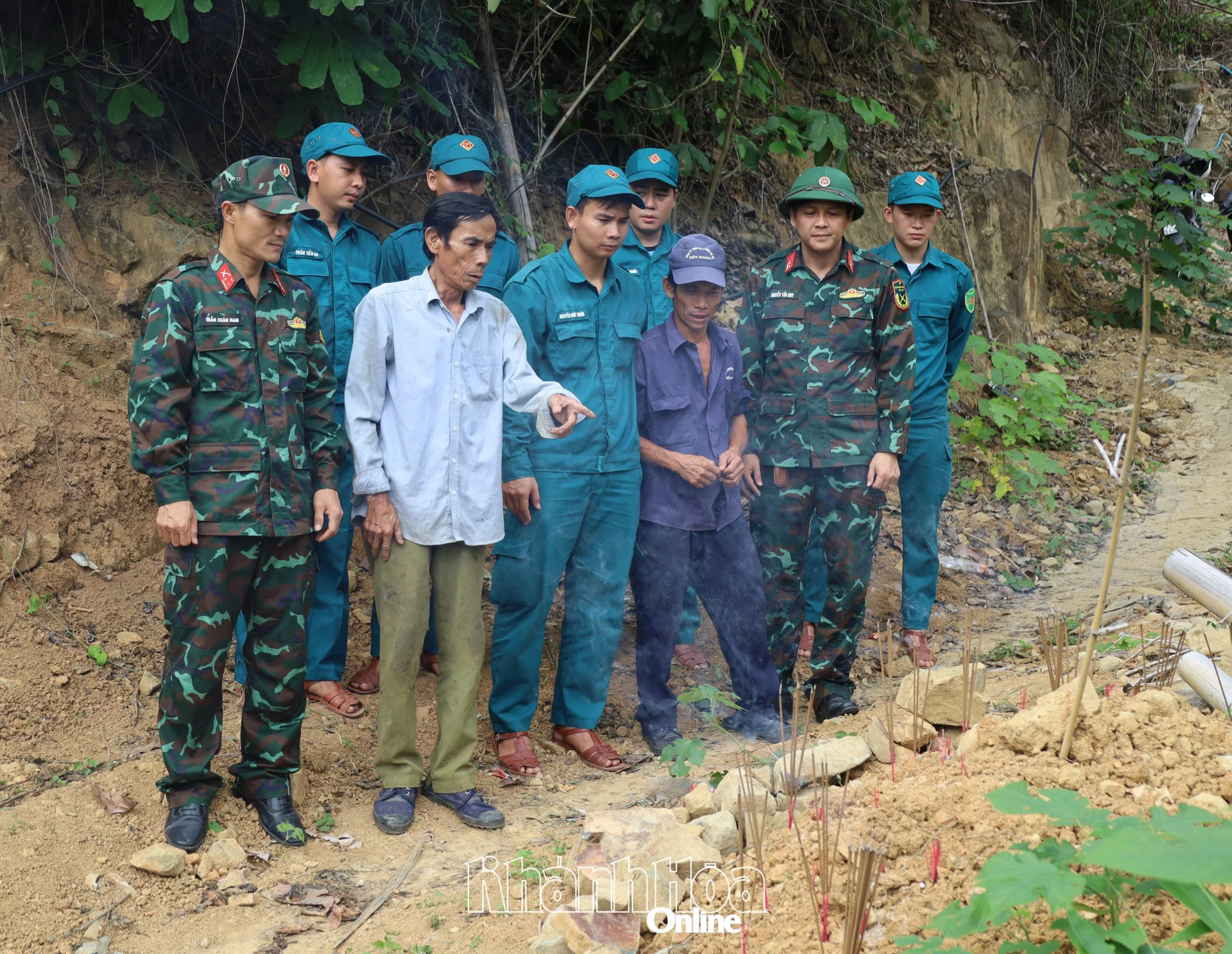 Ông Nguyễn Văn Dũng và đoàn khảo sát bên phần mộ được ông chăm sóc, hương khói suốt hơn 30 năm qua.