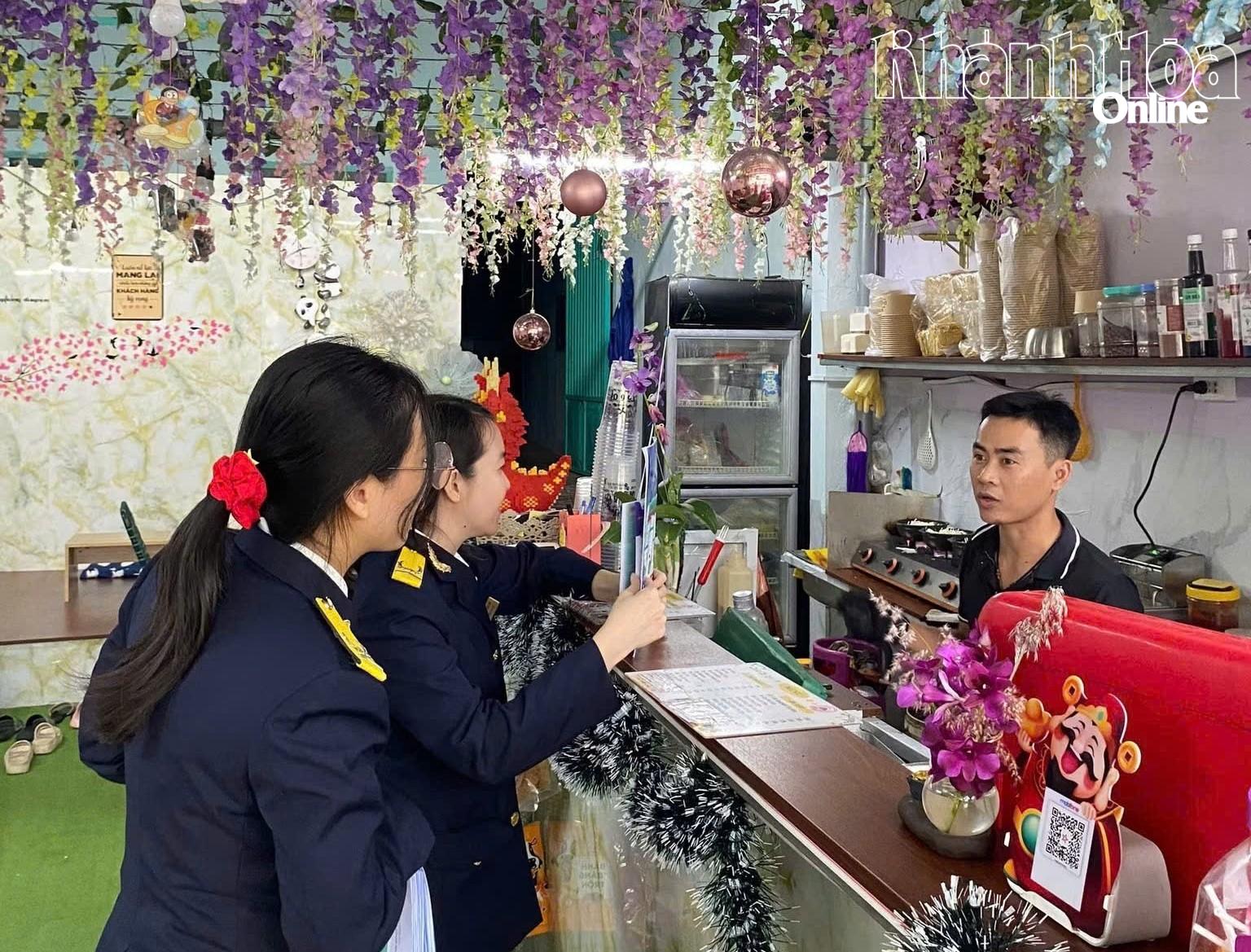 Cán bộ thuế tuyên truyền chính sách thuế mới tại hộ kinh doanh.
