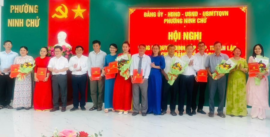 Lãnh đạo Đảng ủy phường Ninh Chử trao quyết định và tặng hoa chúc mừng các chi bộ tổ dân phố mới.