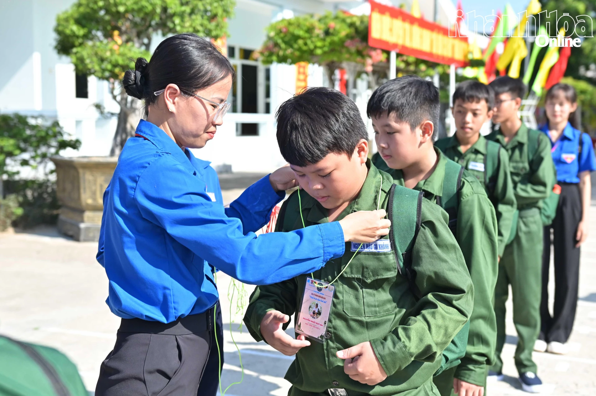 Ban tổ chức đeo thẻ học viên cho các chiến sĩ nhí.