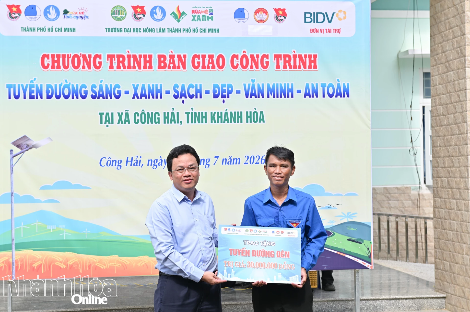Đại diện lãnh đạo Trường Đại học Nông Lâm TP. Hồ Chí Minh bàn giao tượng trưng công trình Tuyến đường sáng - xanh - sạch - đẹp - văn minh - an toàn với 30 trụ điện cho Đoàn xã Công Hải.