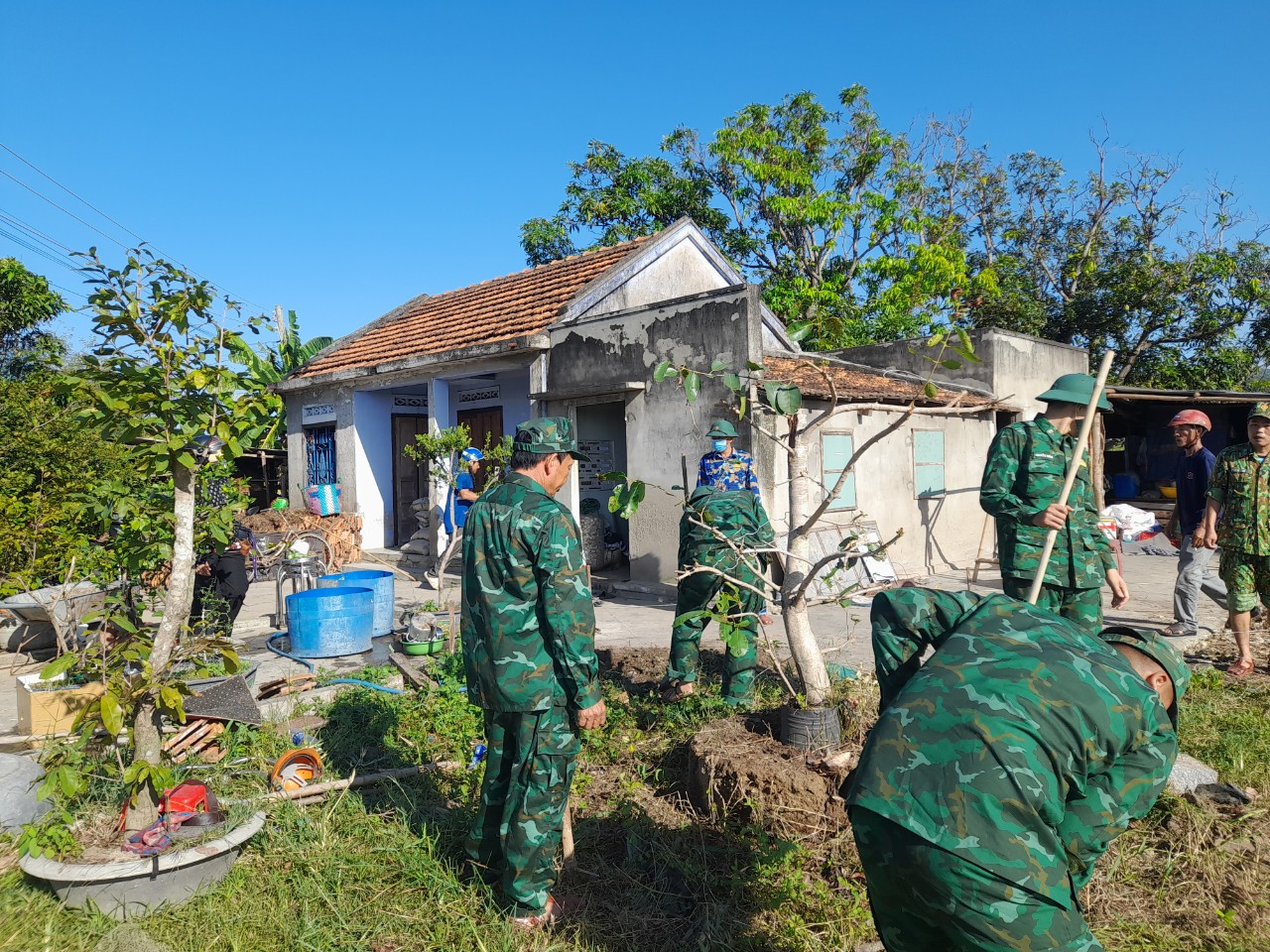 Cán bộ, chiến sĩ Đồn Biên phòng Ninh Hải hỗ trợ dọn dẹp mặt bằng xây dưng nhà cho gia đình bà Nhung.