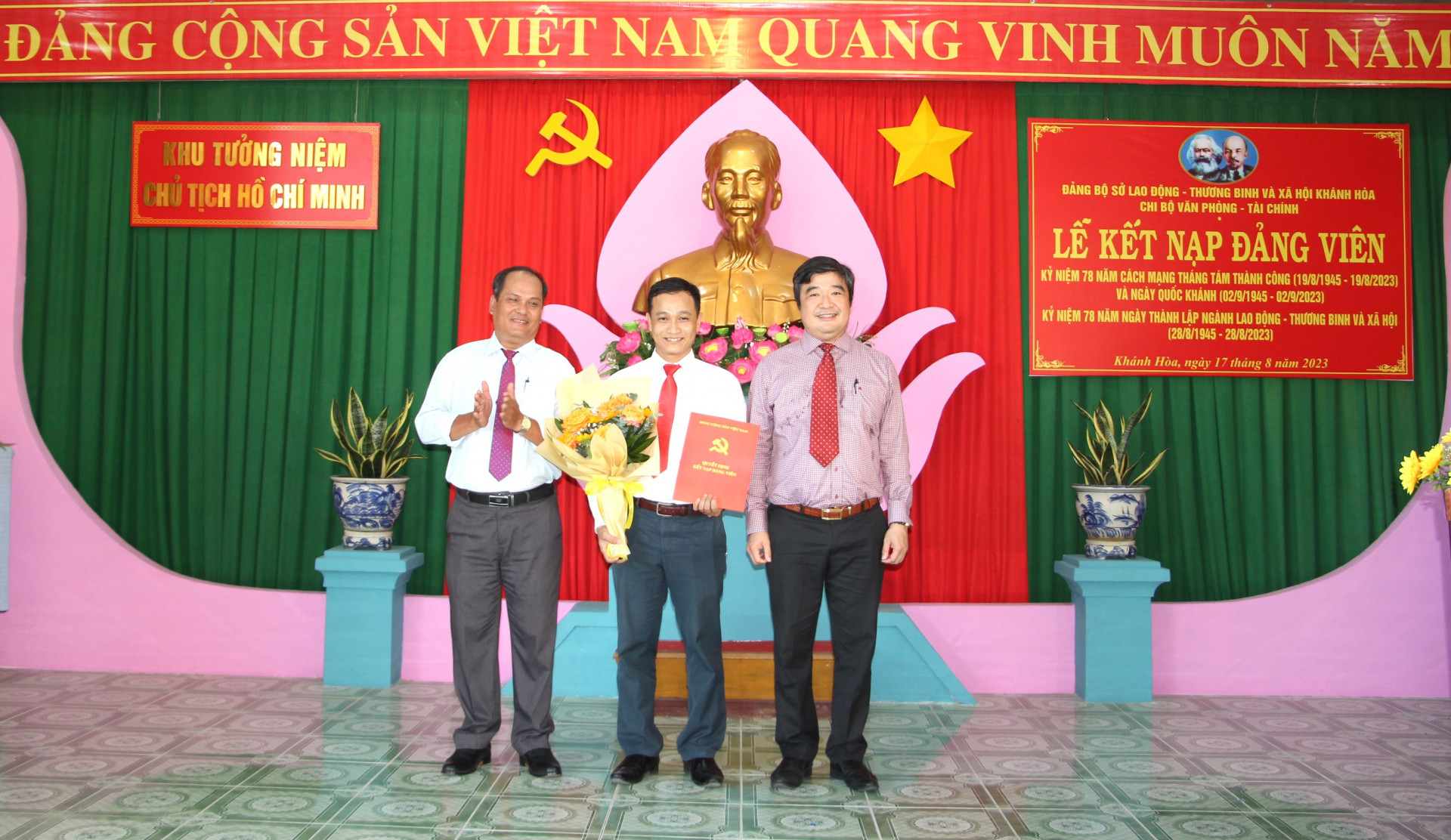 Đại diện Đảng ủy Khối các cơ quan tỉnh và ông Tạ Hồng Quang - Bí thư Đảng ủy, Giám đốc Sở Lao động - Thương binh và Xã hội trao quyết định và hoa chúc mừng đảng viên mới.