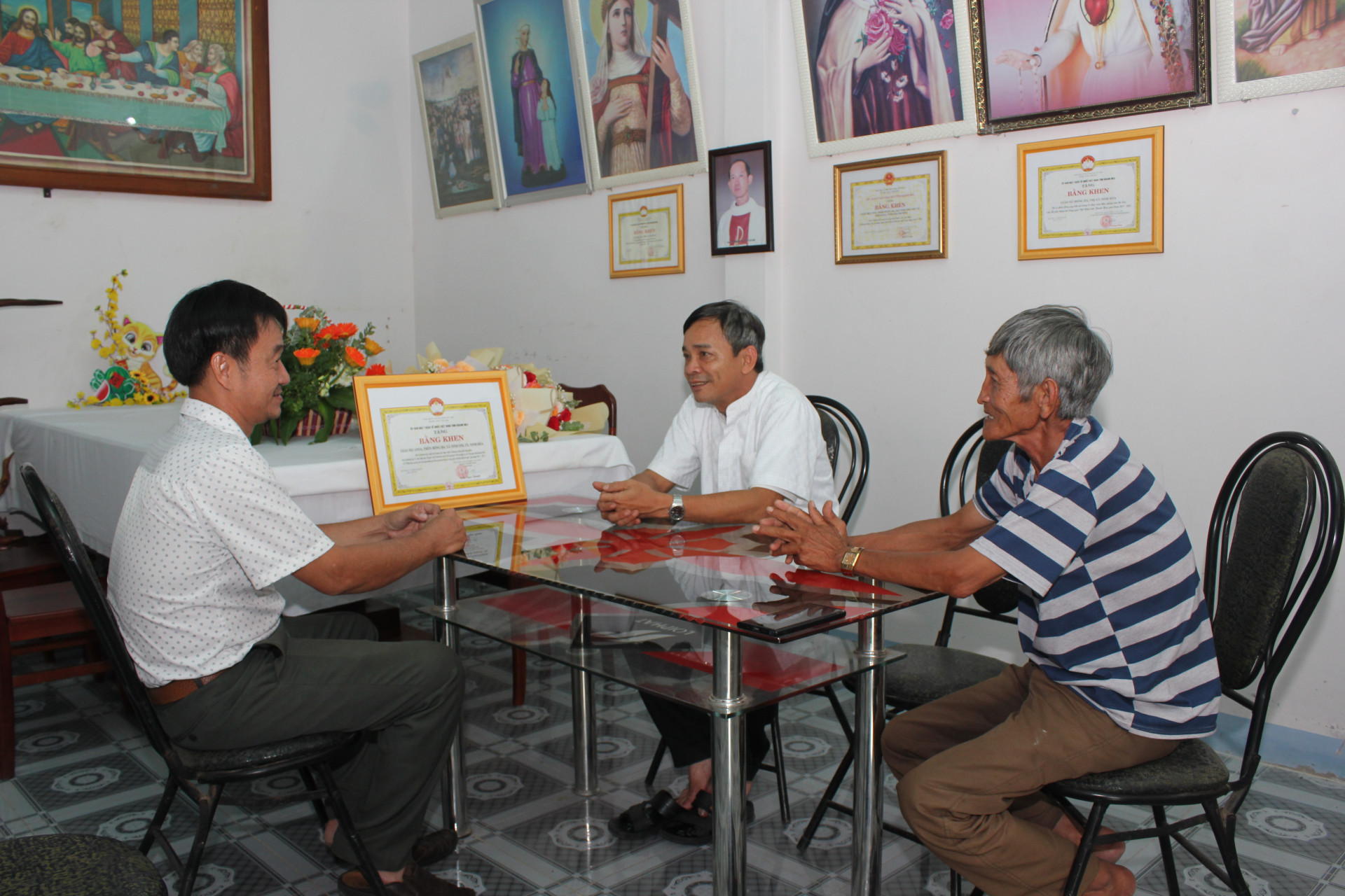 Linh mục Nguyễn Văn Dàng (giữa) trao đổi tình hình hoạt động của Giáo họ Anna với lãnh đạo Mặt trận xã Ninh Sim.
