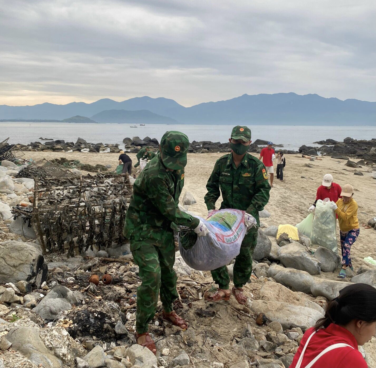 Lực lượng vũ trang và người dân ra quân dọn rác ở bãi biển xã Vĩnh Lương, TP. Nha Trang.