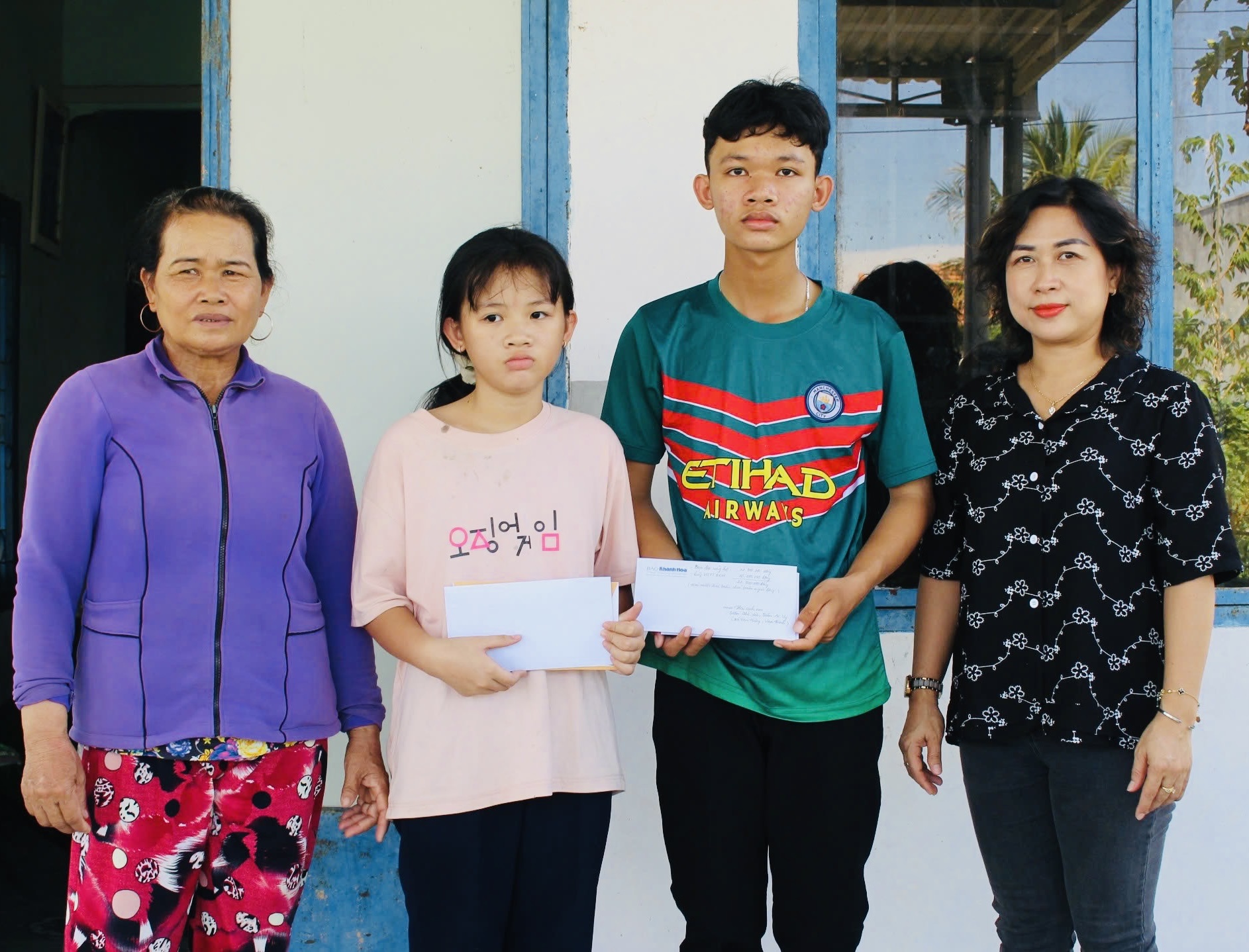 The representative of Khanh Hoa Newspaper giving the donation to Tran The Van and Tran Ai Vy 

