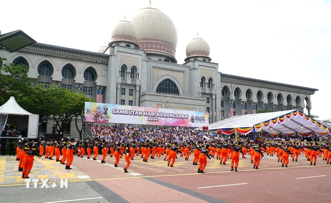 Màn múa của 300 diễn viên trong trang phục màu da cam nêu bật tinh thần chống tham nhũng của Thủ tướng Anwar Ibrahim. (Ảnh: Hằng Linh/TTXVN)

