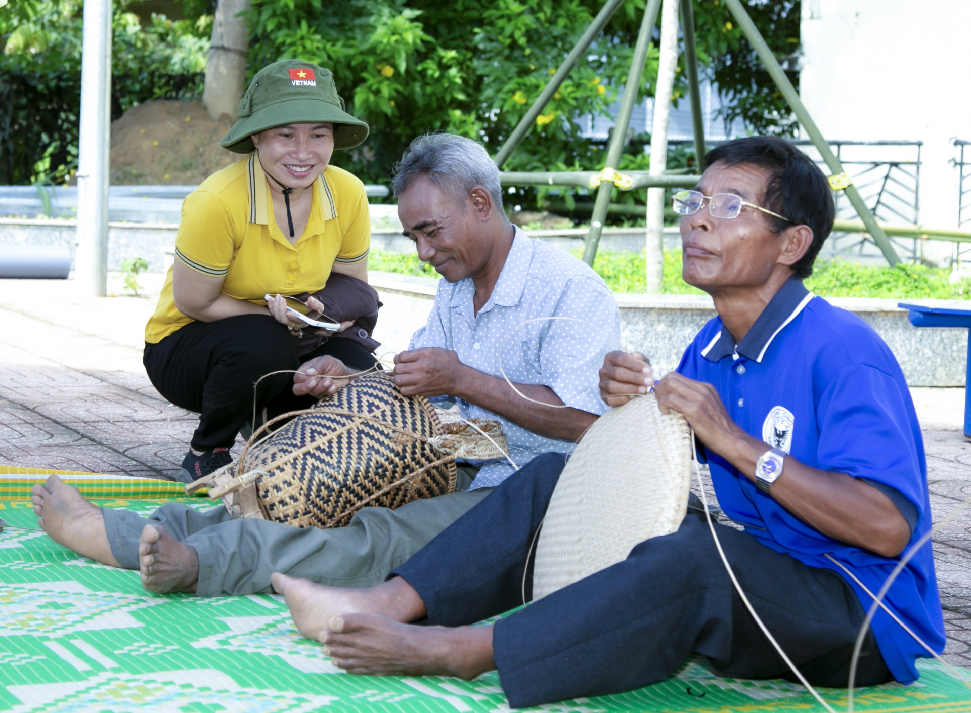 A tourist learning about traditional handicrafts from the Raglai village elders 

