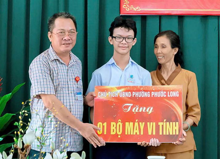 Ông Ngô Khắc Thinh tặng máy vi tính cho em Trần Đức Lương, con bà Ngọc.