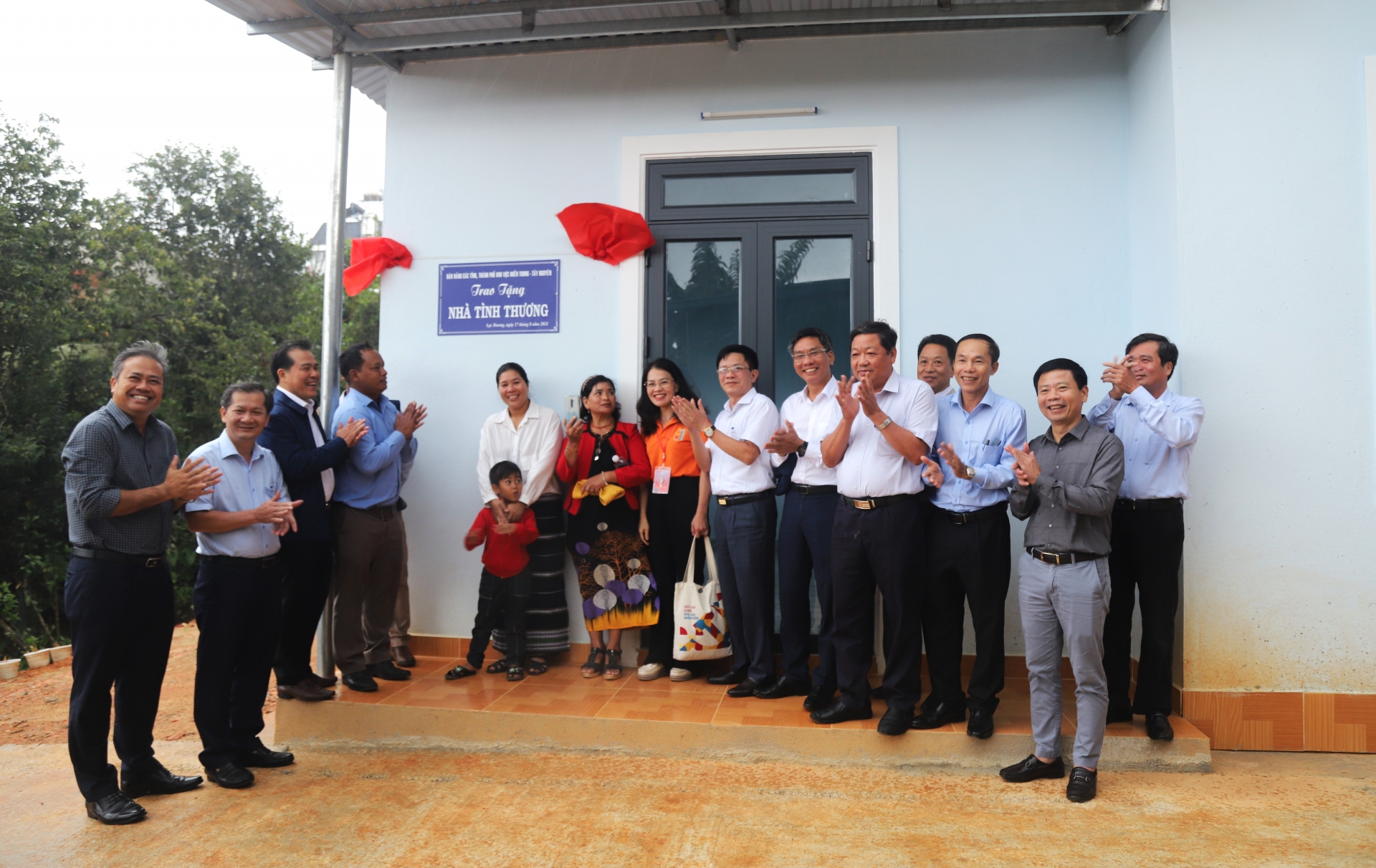 Đại diện các cơ quan báo Đảng khu vực miền Trung - Tây Nguyên trao tặng bảng biểu trưng tặng nhà tình thương cho gia đình anh Ha Chiêng 2