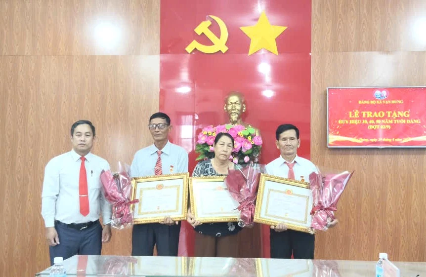 Đồng chí Phạm Huệ - Phó Bí thư Thường trực Đảng ủy xã Vạn Hưng trao Huy hiệu Đảng cho 3 đảng viên.