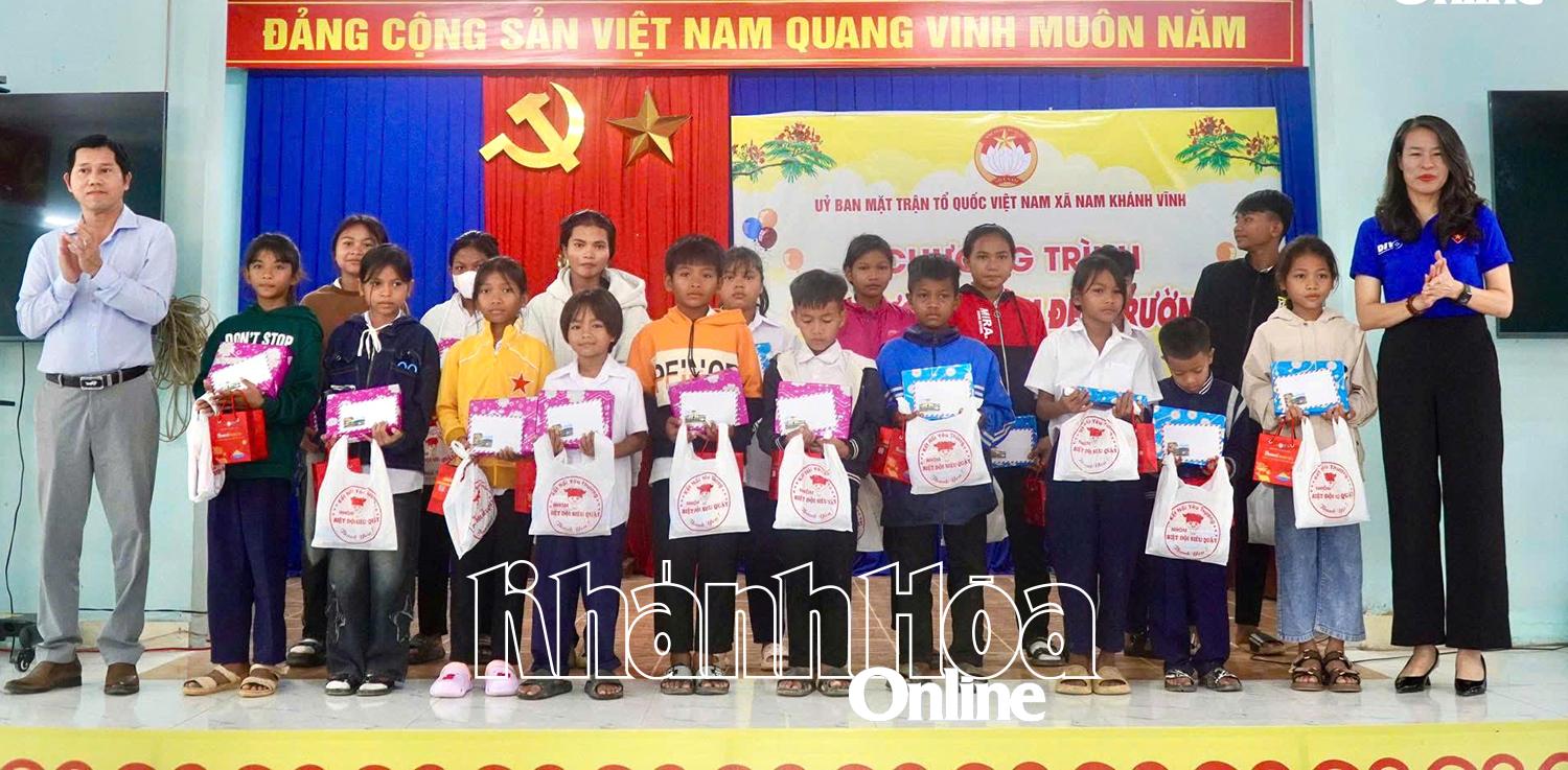 Ông Trần Nguyễn Thái Bình - Bí thư Đảng ủy xã Nam Khánh Vĩnh và đại diện nhà tài trợ trao quà cho các em học sinh.
