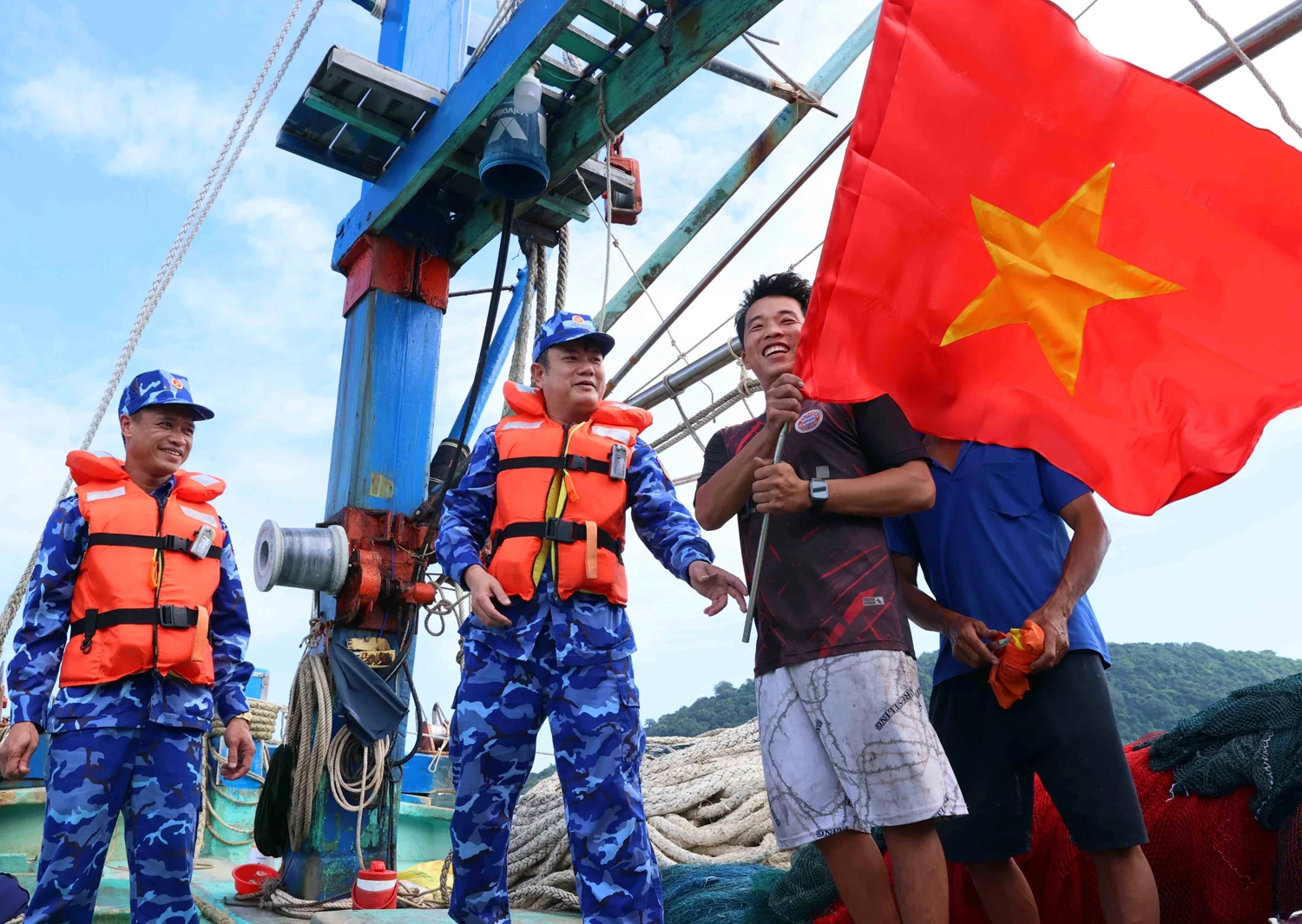 Cán bộ, chiến sĩ Cảnh sát biển Việt Nam tuyên truyền, phổ biến pháp luật và tặng cờ tổ quốc cho ngư dân trên khu vực biển quanh quần đảo Thổ Chu _Ảnh: TTXVN

