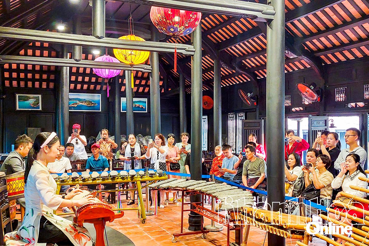 Tourists watch traditional musical instrument performances at the Hon Chong national scenic area.