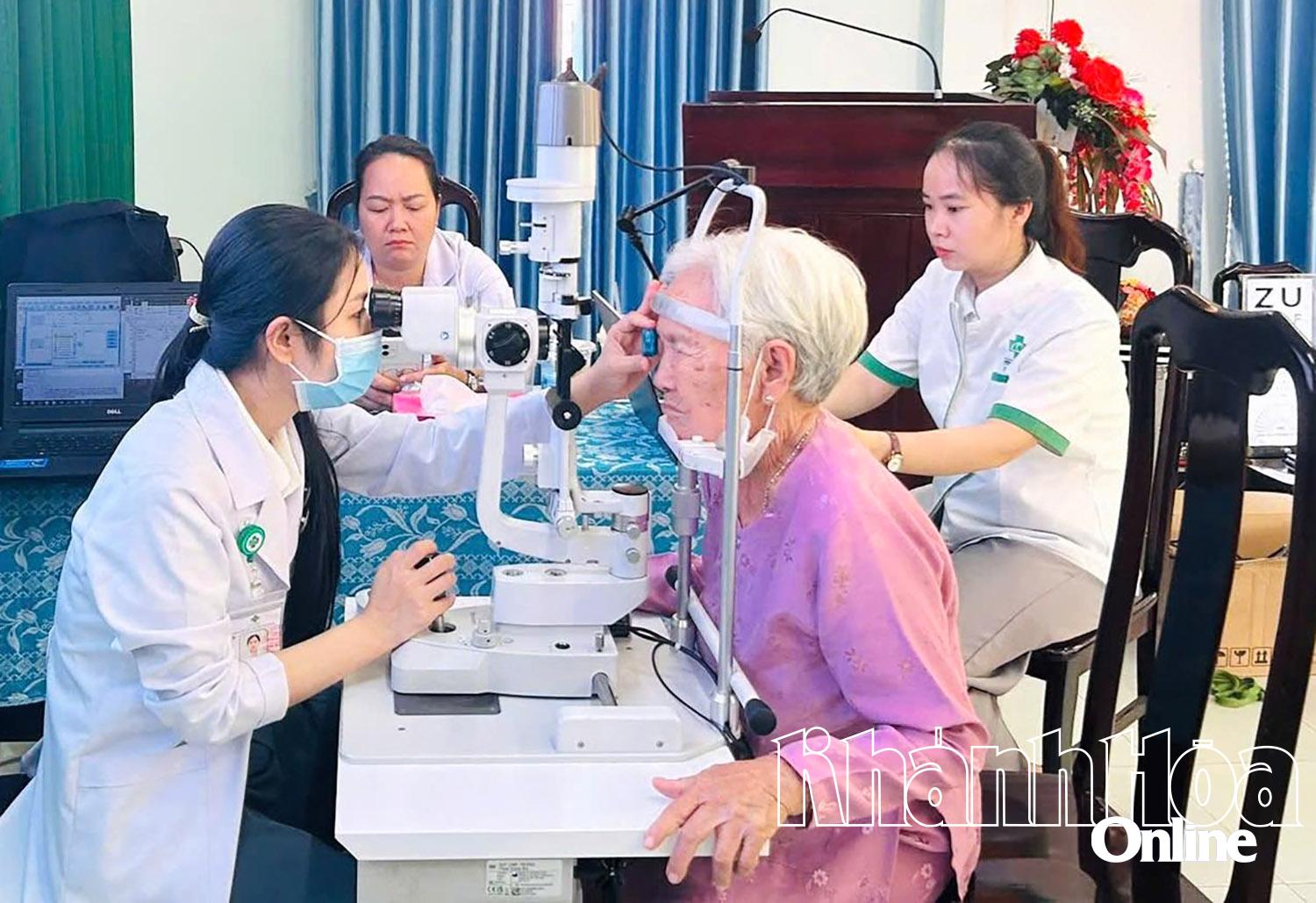 Các bác sĩ tầm soát bệnh lý về mắt cho một người cao tuổi.