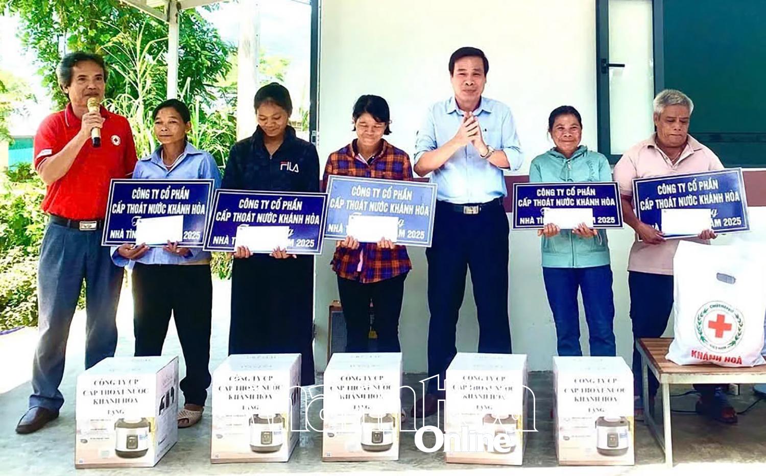 Lãnh đạo Công ty Cổ phần Cấp thoát nước Khánh Hòa trao bảng tài trợ và quà cho các hộ gia đình.