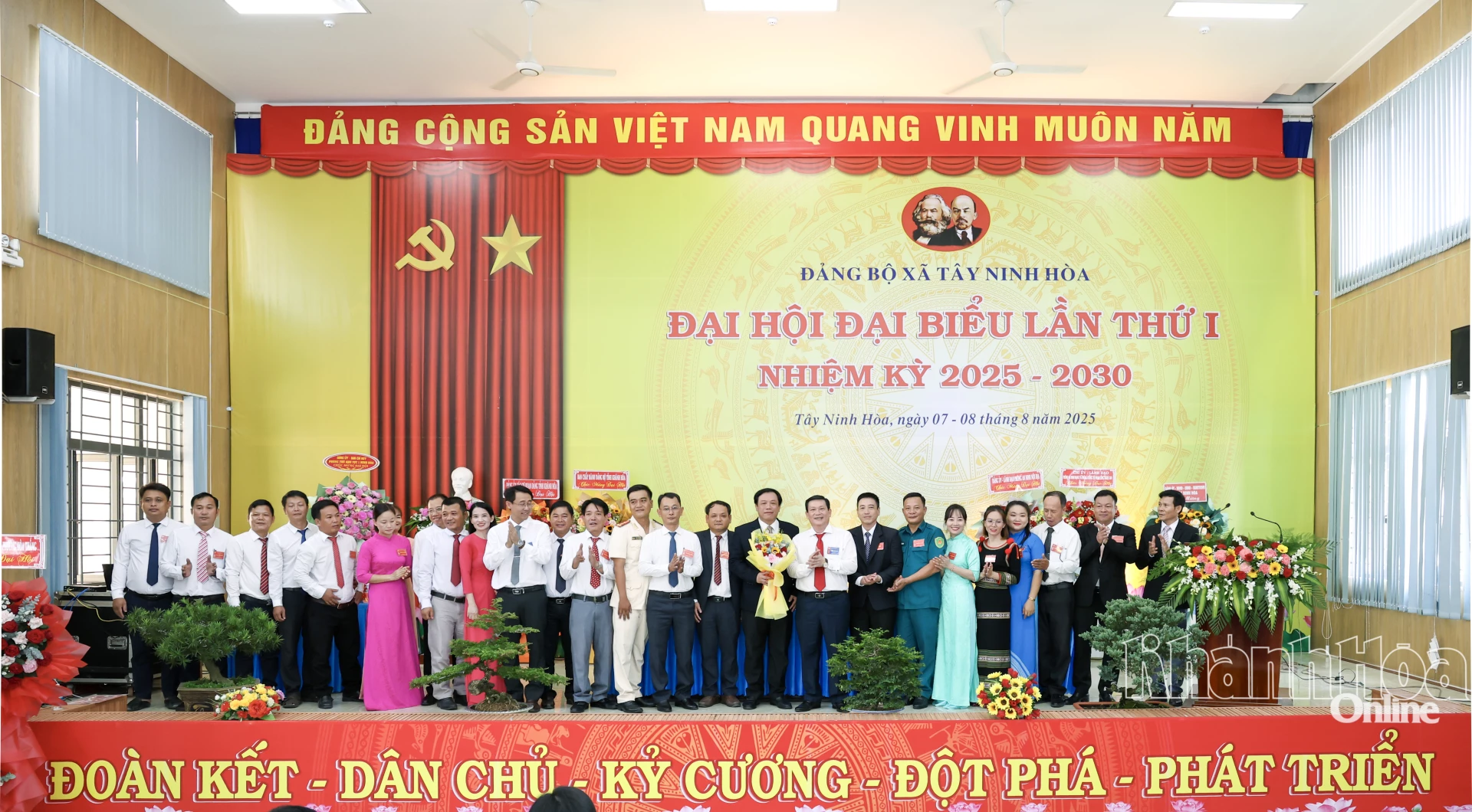 Đồng chí Nguyễn Tiến Đức và các đại biểu tặng hoa chúc mừng Ban Chấp hành Đảng bộ xã