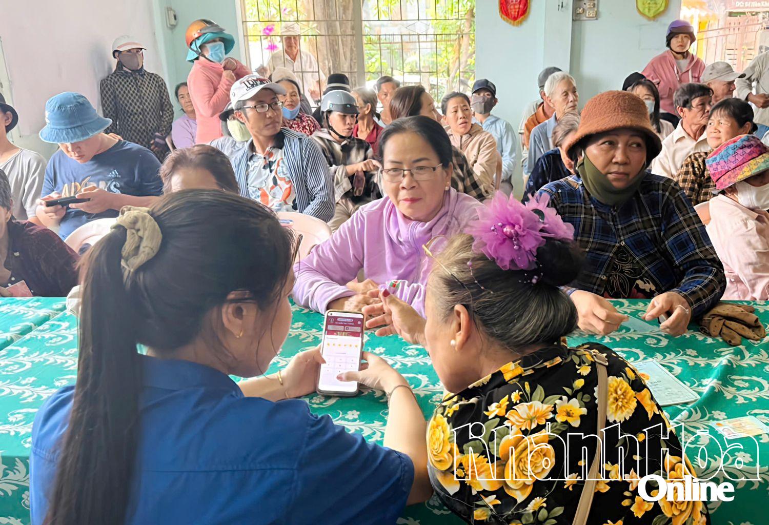Cán bộ phường Đông Ninh Hòa hướng dẫn người dân đăng nhập tài khoản an sinh. Ảnh: Quỳnh Đông.