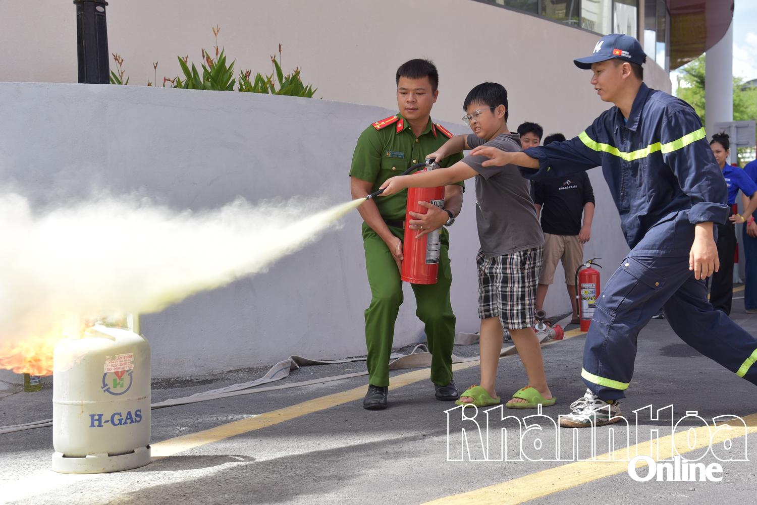 Các thiếu nhi được hướng dẫn cách sử dụng bình chữa cháy.