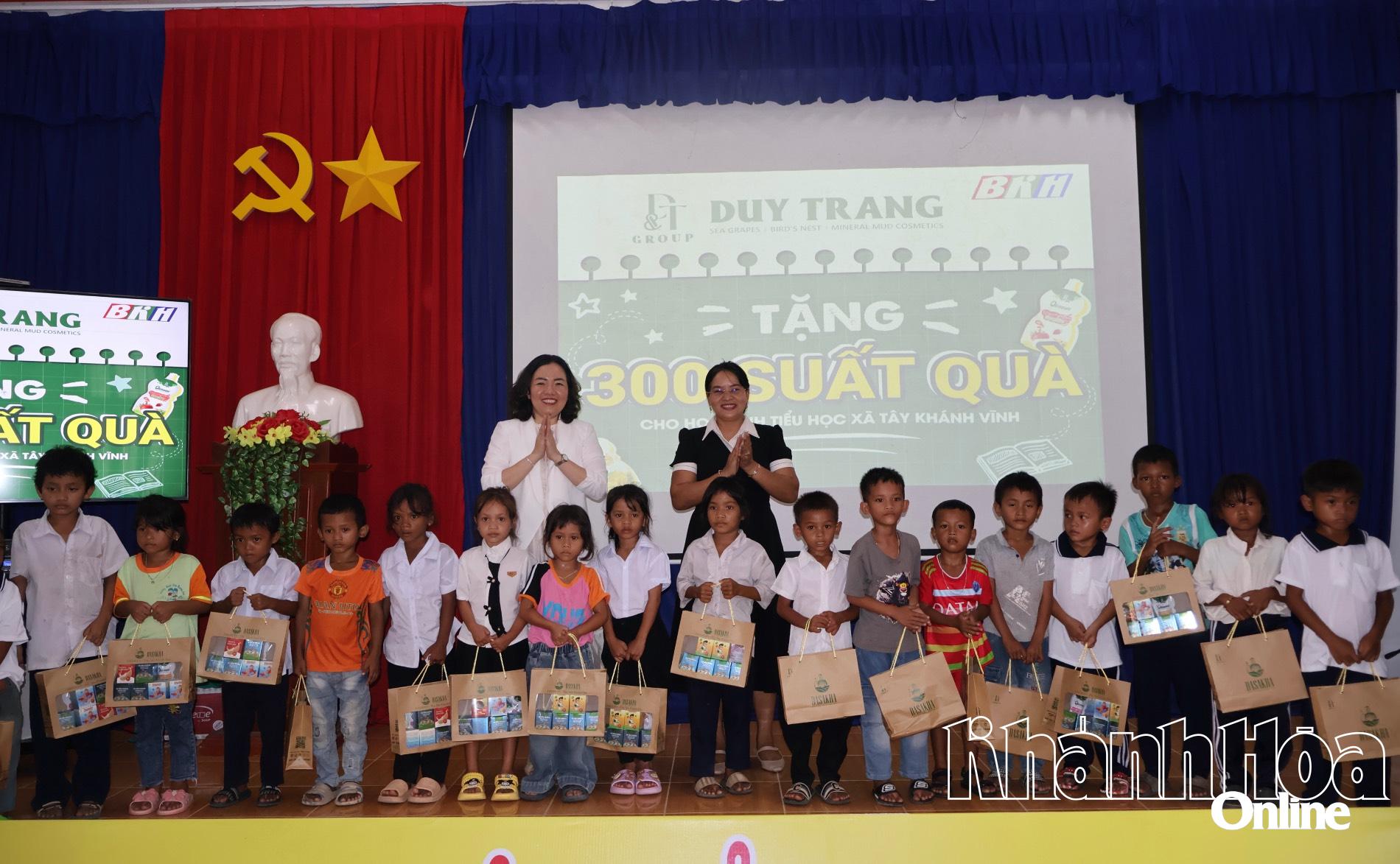 Bà Nguyễn Thị Thu Trang - Phó Tổng Giám đốc Công ty Cổ phần Rong biển DT Khánh Hòa và lãnh đạo UBND xã Khánh Vĩnh tặng quà cho học sinh.