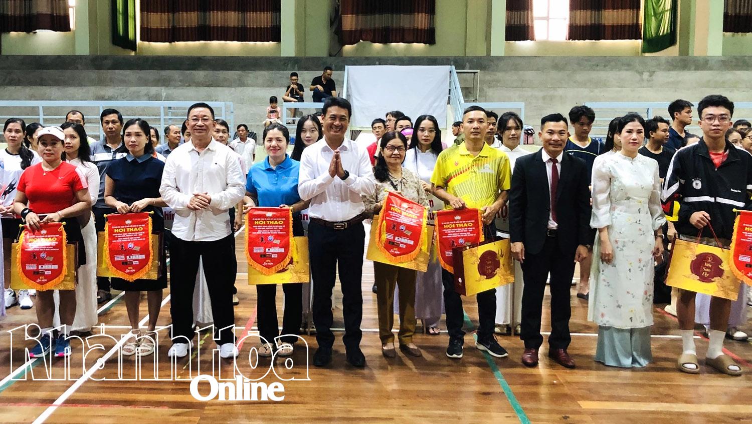 Lãnh đạo xã Vạn Ninh cùng đại diện Mặt trận và Trung tâm Văn hóa - Thông Tin và Thể thao xã tặng hoa chúc mừng các đoàn tham gia.