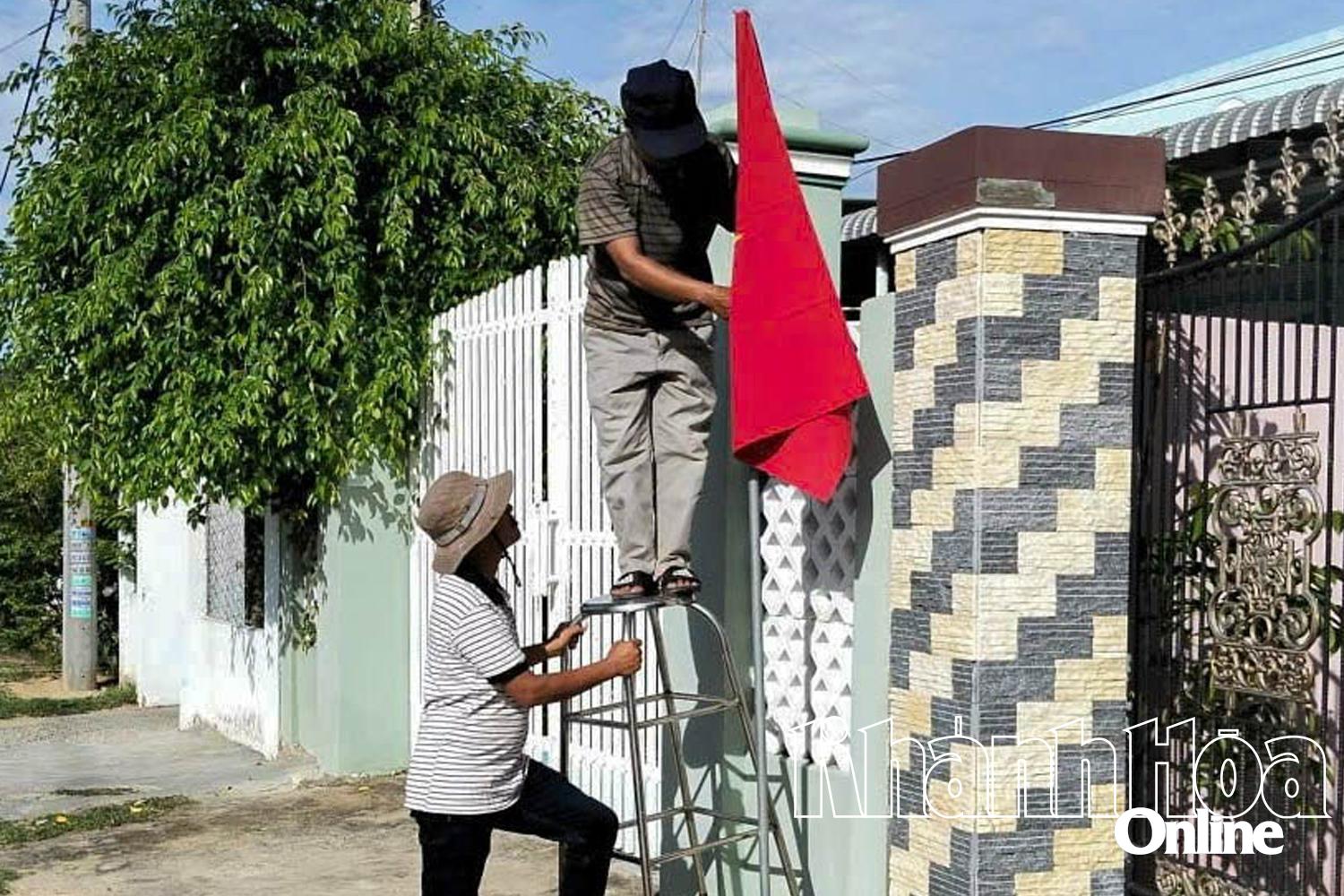 Người dân xã Ninh Hải treo cờ Tổ quốc chào mừng Quốc khánh 2-9.