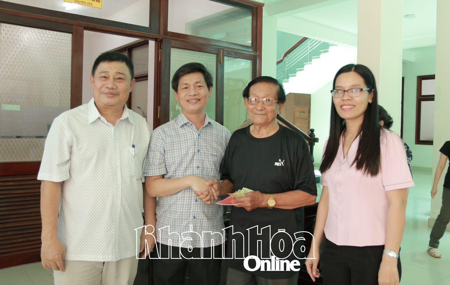 Lãnh đạo phường Phan Rang trao tiền quà cho người dân.