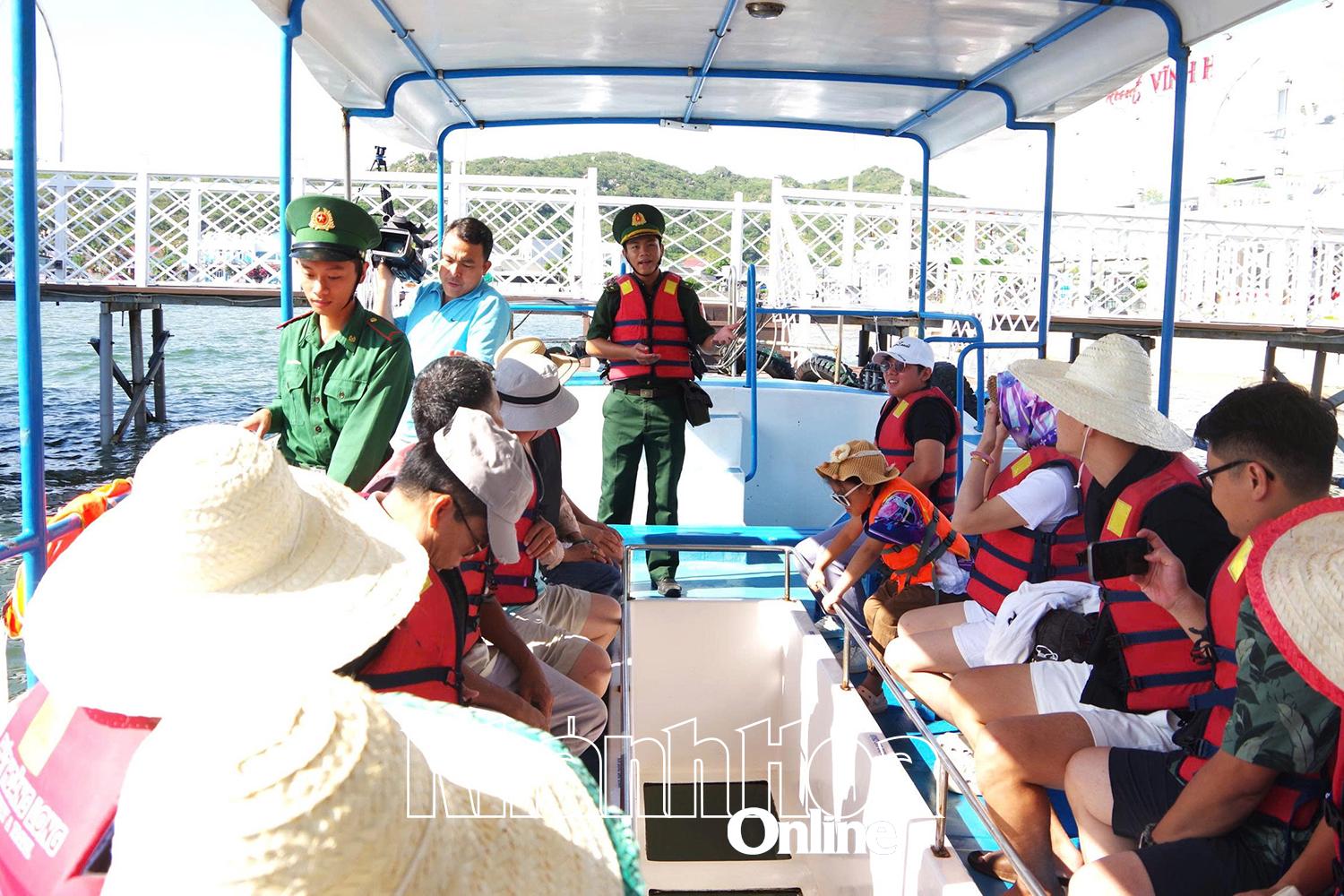 Cán bộ, chiến sĩ Đồn Biên phòng Vĩnh Hải nhắc nhở du khách mặc áo phao trước khi tàu rời bến.
