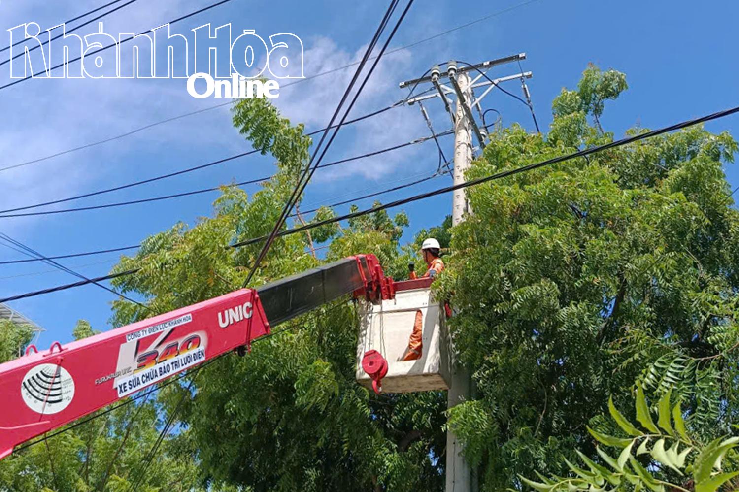 Nhân viên Công ty Điện lực Khánh Hòa chặt tỉa cây xanh giải phóng hành lang, đảm bảo an toàn lưới điện.
