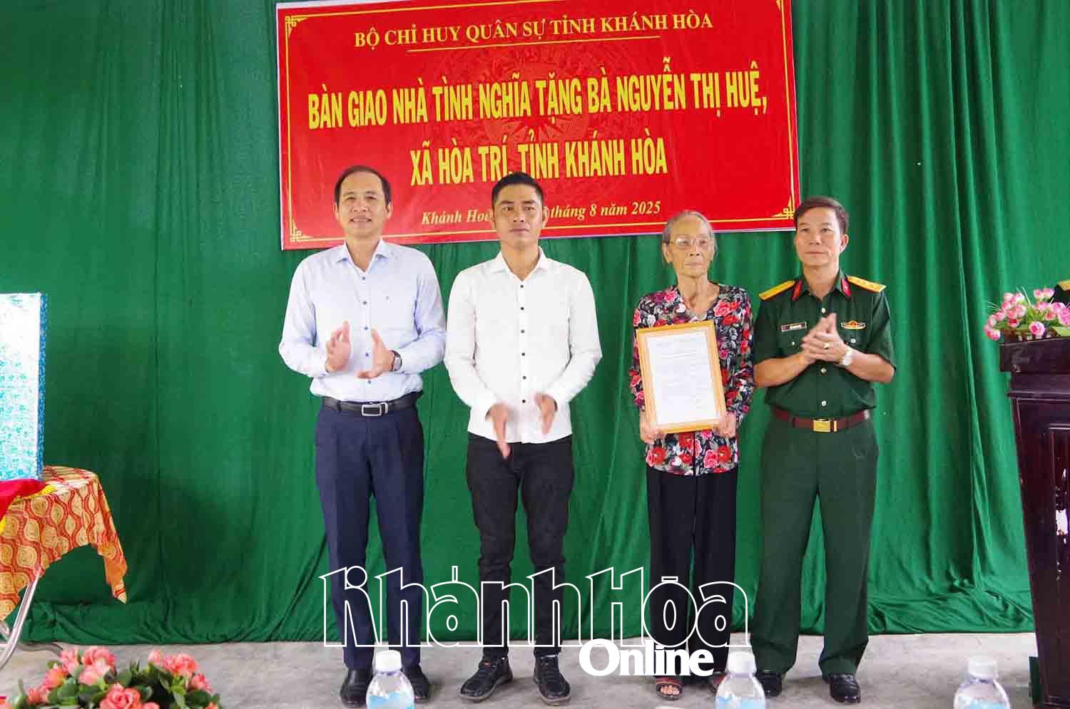 Đại diện Bộ Chỉ huy Quân sự tỉnh trao quyết định bàn giao nhà cho gia đình bà Nguyễn Thị Huệ.