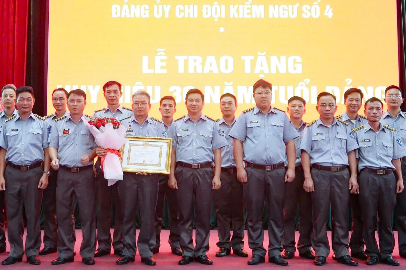 Đảng ủy Chi đội Kiểm ngư số 4 cùng các đảng viên tặng hoa chúc mừng đảng viên Nguyễn Anh Dũng.