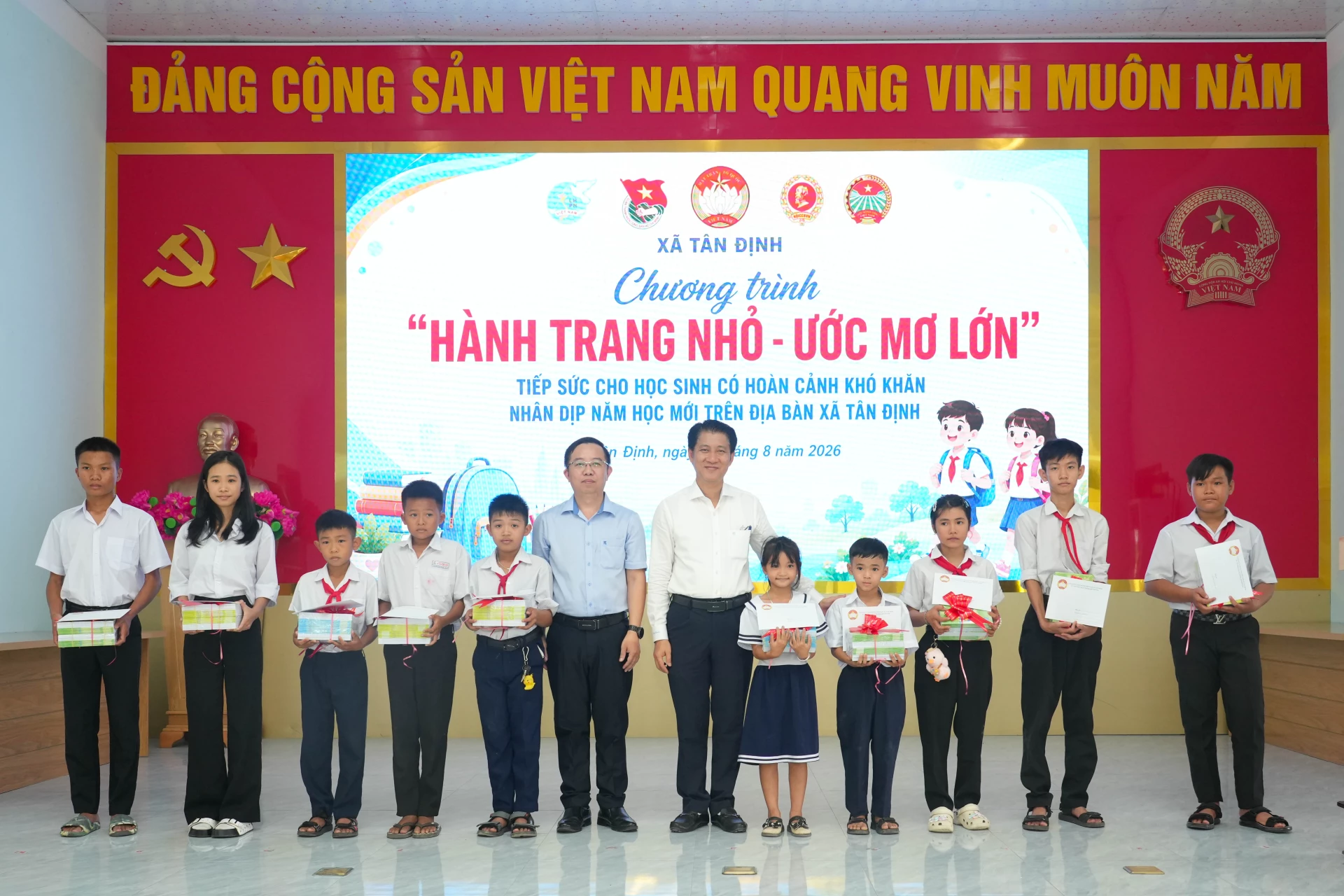 Lãnh đạo Đảng ủy xã và đại diện Tổng Công ty Khánh Việt trao quà cho các em.