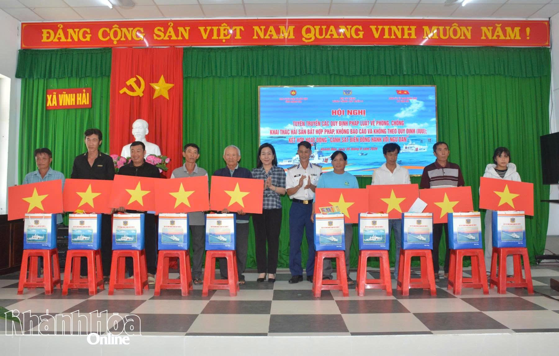 Ban tổ chức tặng cờ Tổ quốc và quà cho các gia đình chính sách.
