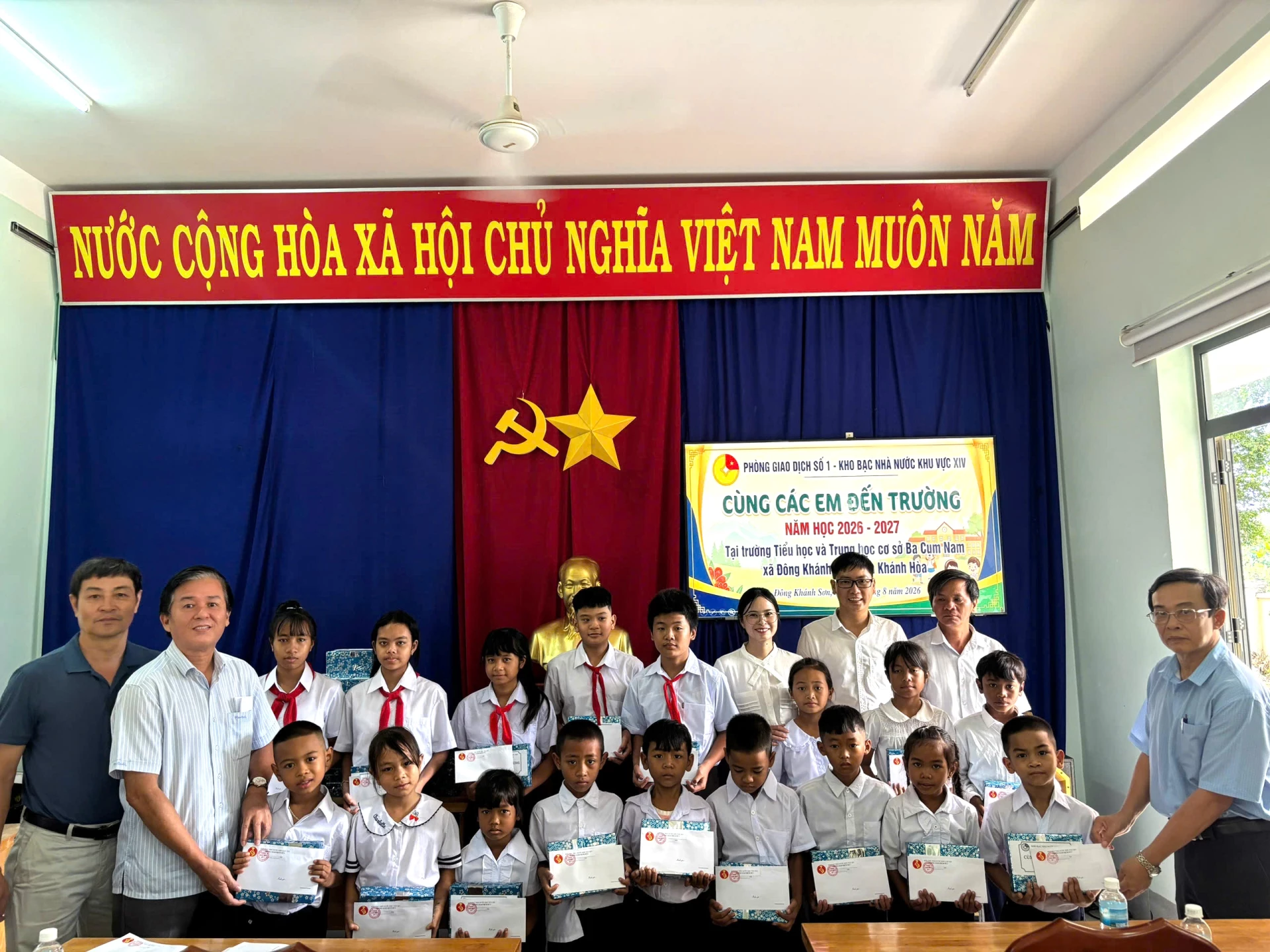 Đại diện Phòng Giao dịch số 1 và Ban Giám hiệu nhà trường trao quà cho các học sinh.