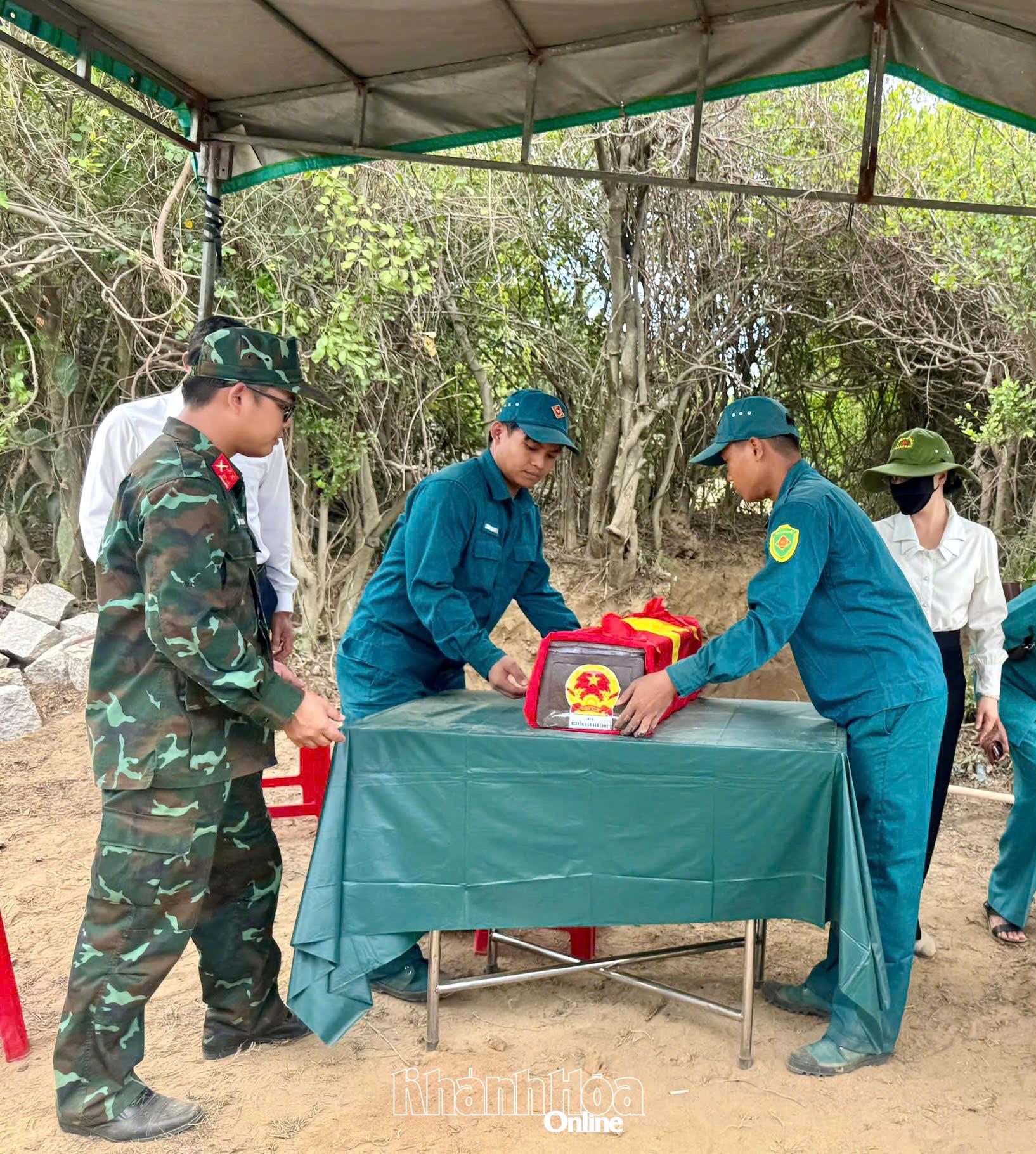 Lực lượng chức năng chỉnh trang linh cữu liệt sĩ Nguyễn Văn Bảo (Em) sau khi hoàn thành công tác cất bốc, quy tập.