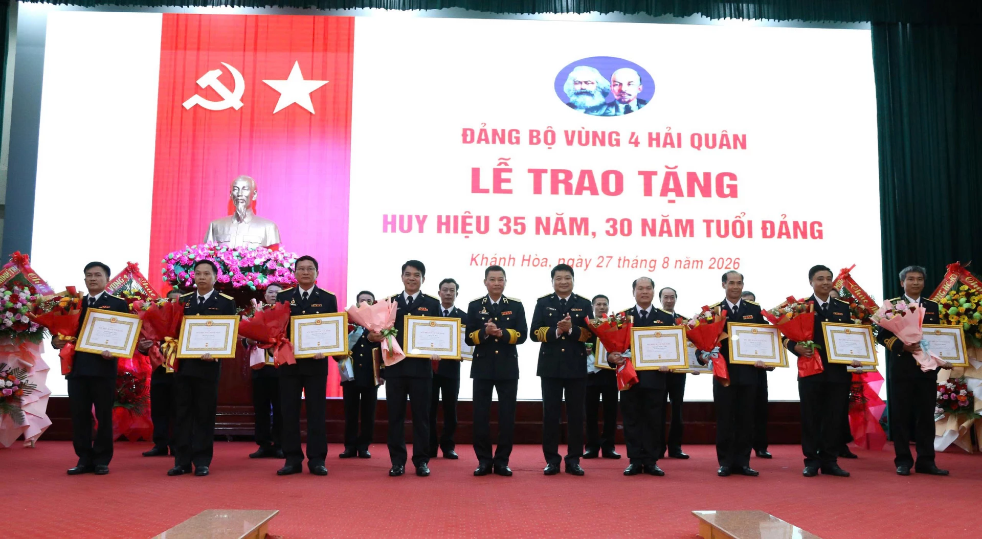 Chuẩn Đô đốc Nguyễn Anh Tuấn và Đại tá Bùi Xuân Bình trao quyết định, tặng hoa chúc mừng các đảng viên nhận Huy hiệu 30 năm tuổi Đảng
