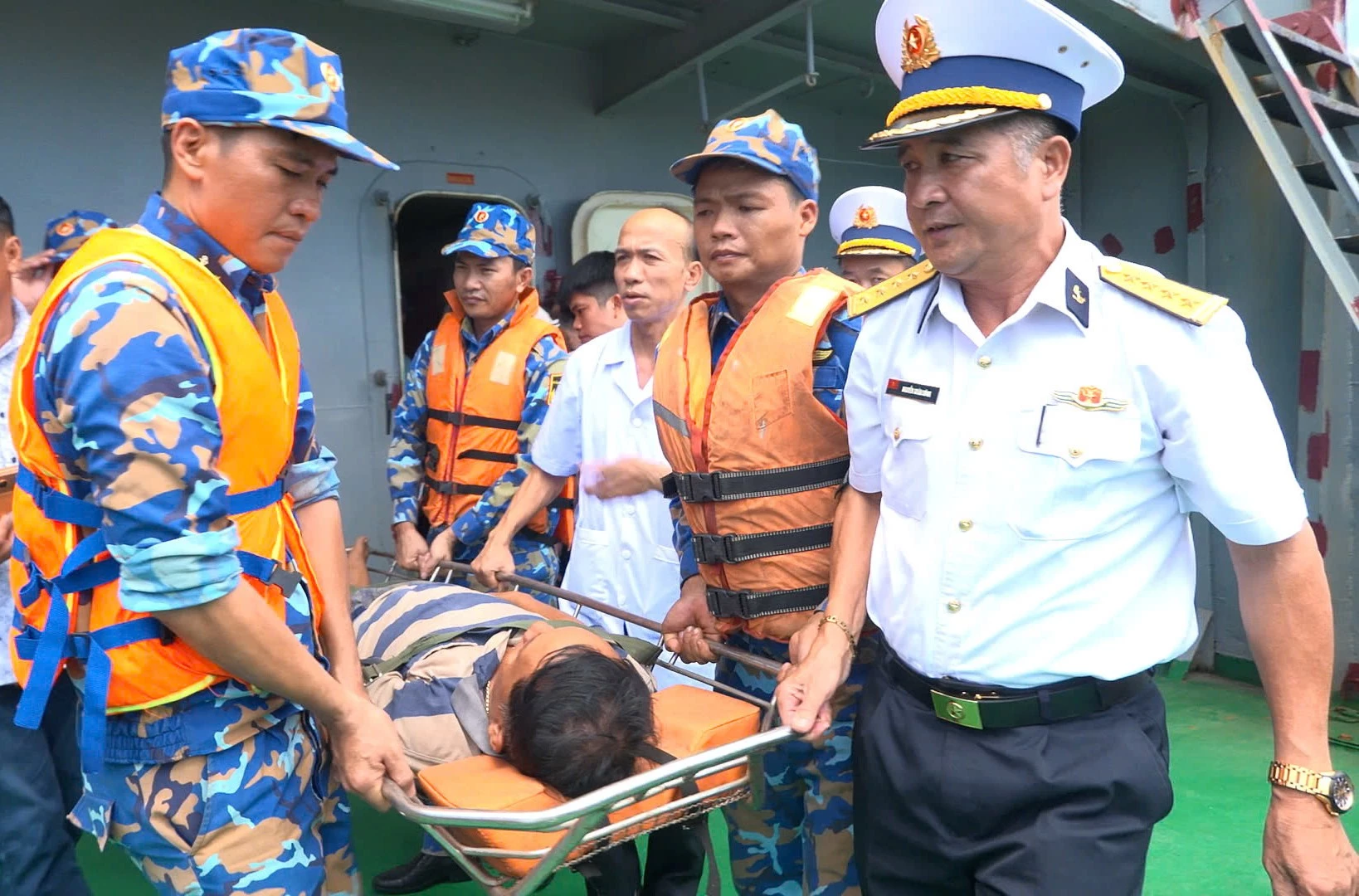 Cán bộ, chiến sĩ và lực lượng quân y đưa ngư dân Nguyễn Đức Quốc từ Tàu TS16 lên bờ