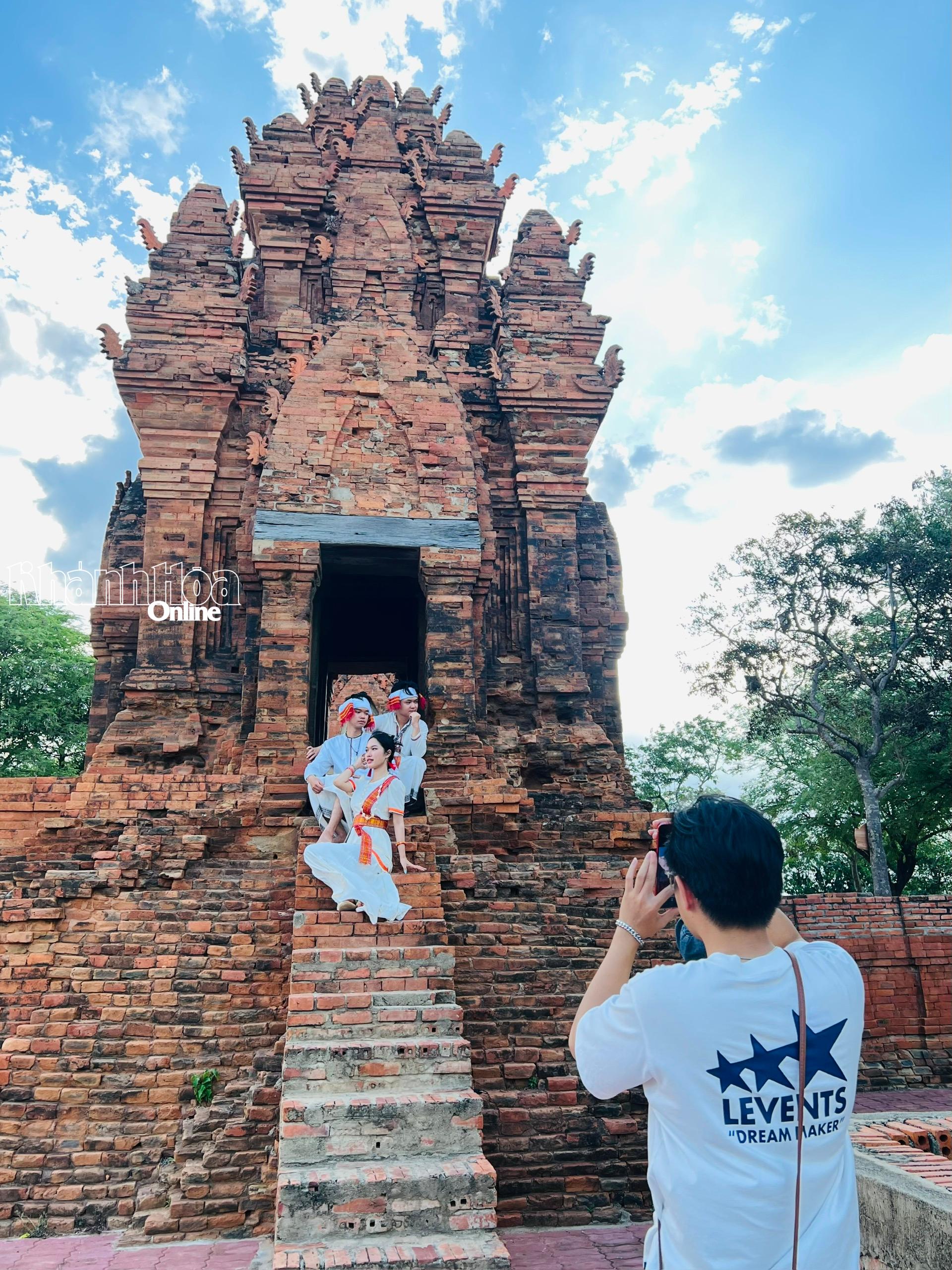 Khách du lịch chụp ảnh lưu niệm với trang phục truyền thóng dân tộc Chăm tại Tháp Pô Klong Garai