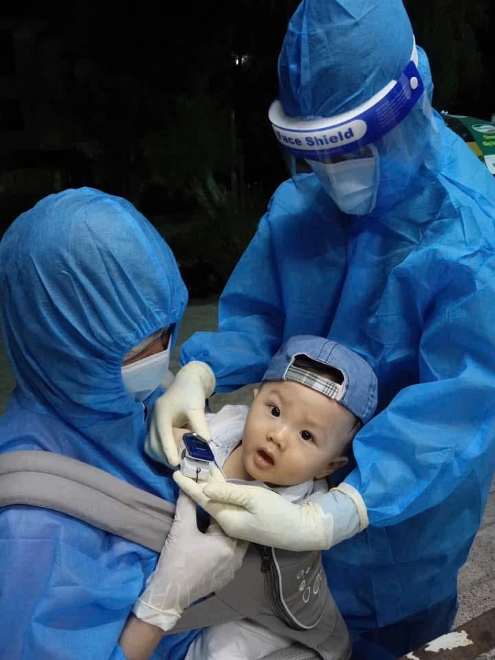 Những thiên sứ dịu dàng. “Sau lớp đồ bảo hộ là những đôi tay vẫn dịu dàng chăm sóc người bệnh, dù đó là một em bé còn quá nhỏ để hiểu về những ngày tháng dịch bệnh.”
