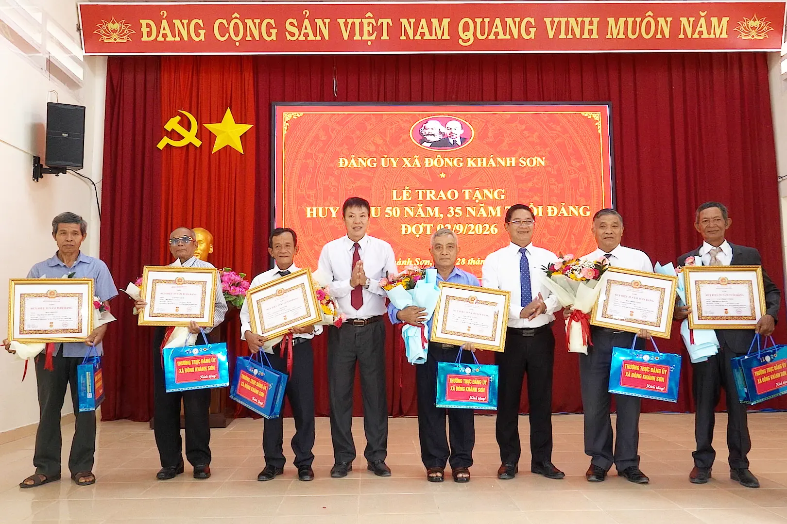 Lãnh đạo Đảng ủy xã Đông Khánh Sơn trao tặng Huy hiệu Đảng và quà chúc mừng các đảng viên.
