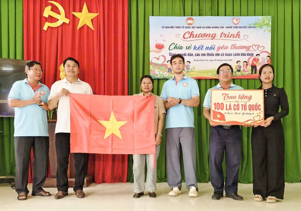 Đại diện Ủy ban MTTQ Việt Nam xã Đông Khánh Sơn và nhóm Tâm Đức Khánh Hòa trao  cờ Tổ quốc cho các hộ dân ở thôn Sơn Trung.